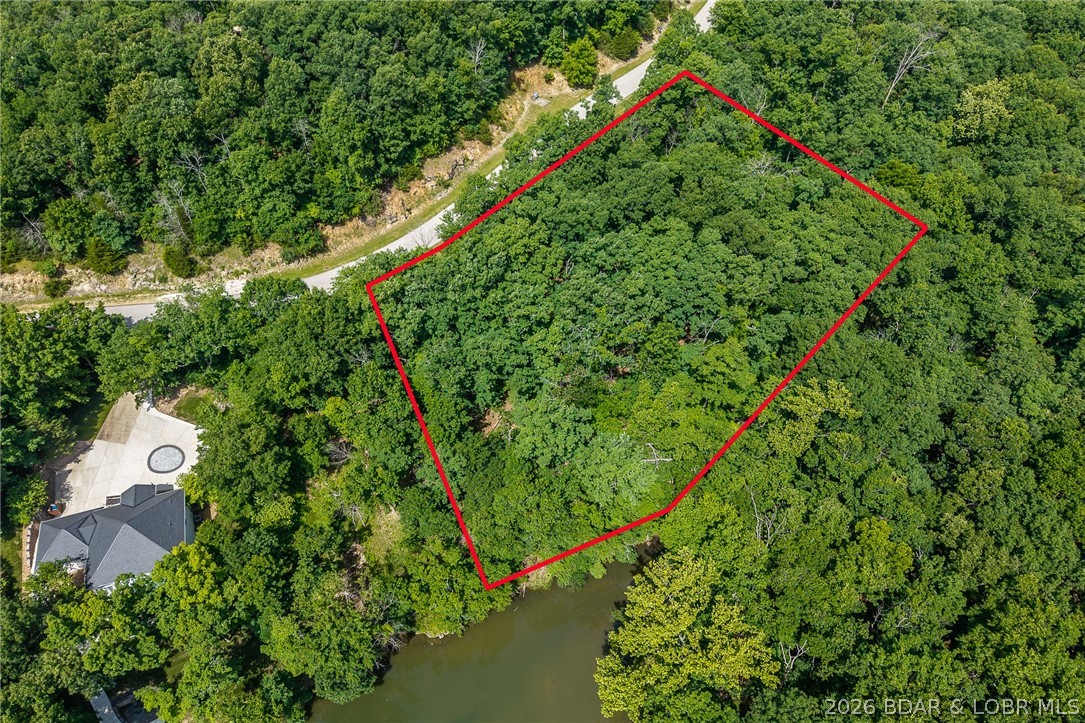 This premier Lakefront lot at The Villages at Shawnee Bend delivers the ultimate Lake of the Ozarks lifestyle with direct water access and breathtaking shoreline views. Arrive through the iconic grand waterfall entrance and enjoy a community known for its upscale amenities and attention to detail. Residents have access to a community marina, elegant clubhouse, multiple pools, championship tennis courts, and pickleball facilities, along with park and playground areas. With paved roads and underground utilities already in place, this lot is perfectly suited for a custom lakefront home with dock potential. A rare opportunity to own lakefront property in one of the lake’s most distinctive communities.