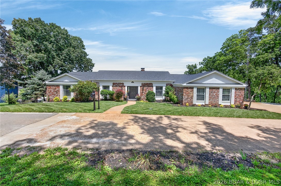 Classic brick ranch meets modern luxury in the heart of Osage Beach! This beautifully reimagined 6-bedroom, 4.5-bath home offers over 5,700 square feet of living space and breathtaking lake views. Sunlight pours through expansive windows, highlighting new engineered hardwood floors and an inviting layout. The stunning kitchen features custom two-tone cabinetry, quartz countertops, an 8-foot waterfall island, black stainless Café appliances, and elegant finishes. The main level also offers a formal dining room, sitting room, spacious living area, guest bedrooms, and an incredible primary suite w/ attached bath offering heated tile floors, soaking tub and oversized tiled shower. The lower level is built for entertaining with a massive family room, custom wet bar, and a hidden speakeasy behind a bookcase complete with a walk-in vault room and concealed wall safe. Additional bedrooms, updated baths, and a private lakeside en-suite provide plenty of room for family and guests. Outside, a newly poured concrete cart path leads to 30 feet of lakefront and a brand-new 22x50 concrete dock with a 14x40 slip in deep water. Close to everything Osage Beach has to offer!