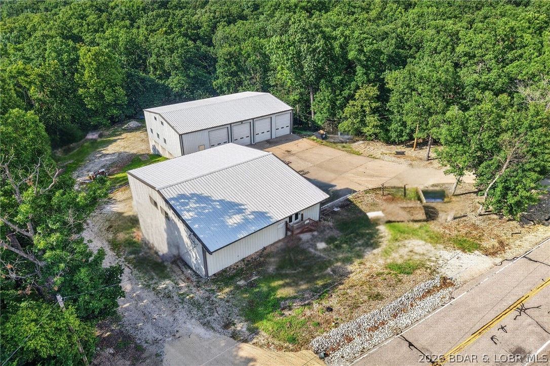 Zoned B-1 Commercial and ideally located just off Horseshoe Bend Parkway, this versatile 4.1-acre commercial property offers outstanding accessibility and endless potential for a wide range of business uses. The primary building encompasses approximately 7,500 square feet and features a spacious open upper level with four 12' x 14' overhead bay doors, a half bath, and a loft area—ideal for warehouse, retail, or service operations. The lower level includes five individual storage units, each approximately 750 square feet, with 10' x 12' overhead garage doors and electric, providing excellent rental income potential or additional storage space. The second building offers approximately 3,000 square feet and is well-equipped with two overhead bay doors (12' x 12' and 12' x 14'), a workshop with a half bath, an office/lobby area, and a private office complete with a full bath. With ample acreage, easy access, and flexible building configurations, this property is perfectly suited for a variety of commercial ventures. The possibilities are truly limitless!