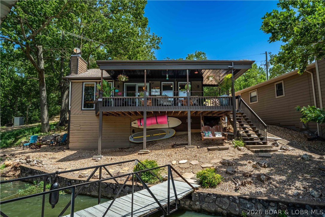 Privacy, gentle lakefront living, and room to enjoy everything the Lake of the Ozarks has to offer—this charming 2-bedroom, 1-bath retreat checks all the boxes. Nestled on nearly an acre with over 125 feet of lake frontage, this property offers a rare combination of space, seclusion, and convenience just minutes from Laurie, restaurants, shopping, and local attractions. Inside, you'll find an updated home featuring beautiful hardwood floors, a warm interior, and a rustic covered lakeside patio that's perfect for grilling, entertaining, or relaxing with lake views. The new roof and updated septic system provide added peace of mind. The outdoor setting is what truly sets this property apart. The nearly flat lot offers an easy walk with hardly any steps to the one-well dock with hoist. A boat ramp shared by only five homes adds even more convenience. Two detached garages/shops provide plenty of space for vehicles, boats, lake toys, a workshop, or extra storage. Whether you're searching for a weekend escape, full-time residence, or the perfect Lake of the Ozarks retreat, opportunities like this are becoming increasingly difficult to find.