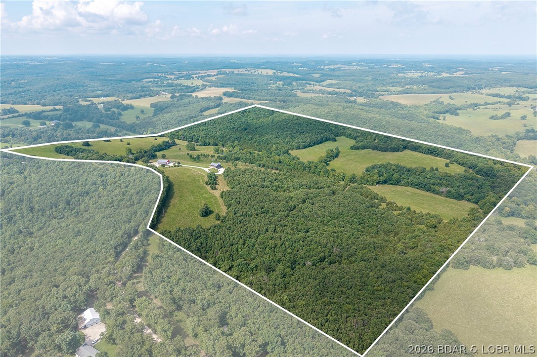 Experience luxury, privacy, and country living on this extraordinary custom-built 3-bedroom, 3-bath estate on approximately 150 breathtaking acres in Crocker, MO. The property features 50 acres of pasture, mature timber, abundant wildlife, panoramic views, a walnut and chestnut grove, orchard, raised gardens, and grape arbor. The home offers an open-concept design with cathedral cedar tongue-and-groove ceilings, exposed beams, and a gourmet kitchen featuring custom walnut cabinetry, quartz countertops, Café appliances, double ovens, and a walk-in pantry. The main-level primary suite includes a walk-in closet and bath, with a second bedroom, full bath, and office also on the main floor. The finished walkout basement adds a third bedroom, full bath, recreation room, and cedar-lined safe room. Enjoy a covered composite deck, covered patio wired for a future sauna and hot tub, oversized garage, and a 40x60 shop with its own well, septic, 50-amp RV hookup, 14' drive-through doors, workshop, and finished living quarters. Conveniently located near Fort Leonard Wood and Lake of the Ozarks, this remarkable property is ideal as a luxury home, farm, hunting retreat, or equestrian estate.