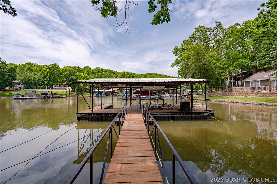 This may be the lake lifestyle you’ve been waiting for. Imagine lake days starting right outside your door. This beautifully remodeled, move-in-ready lakefront home offers room to relax, entertain & make lasting memories. The open main level brings everyone together with a spacious living area, quartz countertops, an oversized island, walk-in pantry, built-in storage & a cozy fireplace. Step onto the deck or patio to enjoy peaceful mornings or evenings by the lake. Your primary suite feels like a true getaway with a sitting area, fireplace, deck access, office, large walk-in closet & spa inspired bath. The walkout lower level includes a second kitchen, dining area, family room, two bedrooms & a full bath perfect for family & guests. When you’re away the layout also offers rental-income possibilities with the flexibility to rent the home as one spacious retreat or create two separate rental areas. Outside nearly an acre gives you room to spread out. A short path leads to a two-slip dock with new decking, swim platform, lift & good water. Gather around a future firepit area, store your lake toys in the heated garage/shop and don't worry there's plenty of parking here.