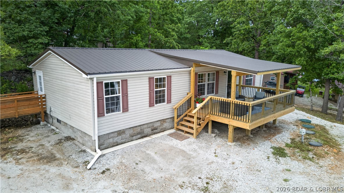 Beautiful waterfront opportunity at the 83 Mile Marker of the Lake of the Ozarks offering the perfect combination of lake living, updates, & functionality. Situated on 3.5 total lots, this 3-bedroom, 2-bath home features a spacious master suite with two closets and an updated interior completed in 2024. Numerous major improvements have already been completed, including a new well in 2023, new septic system with lift station in 2024, and a new roof and three brand-new decks all completed in 2026. Outside, the property is designed for enjoying the lake lifestyle with tons of parking, a fenced dog yard, room to build a garage, and a full RV hookup site with 50-amp electric and additional parking space for guests. The impressive 54’x34’ permitted covered dock includes two slips (10’x24’ and 16’x14’), with one currently set up with two jet ski lifts, along with a large 24’x30’ swim platform, storage room, and separate privy closet. Community areas include a park and boat ramp right down the road! This property offers outstanding amenities and plenty of room to enjoy everything lake life has to offer!