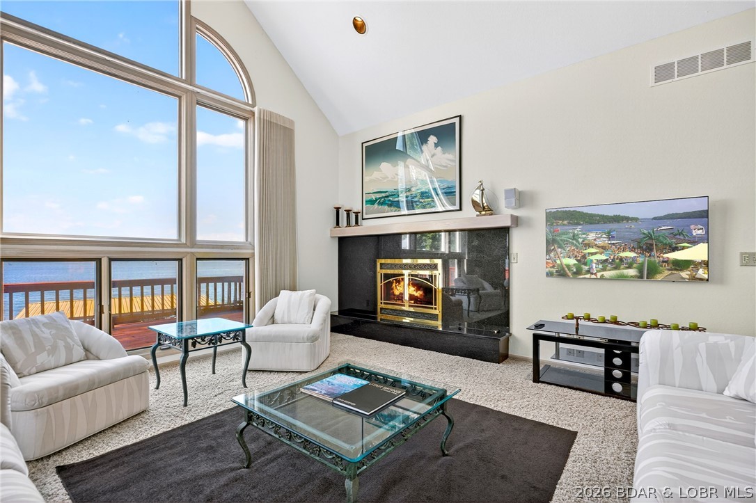 609 Point Charles Rd in Sunrise Beach offers luxury lakefront living with 3,700 sq ft, main-level living, and breathtaking views at the 31 MM. This 3-bedroom, 2.5-bath retreat features vaulted ceilings, an open floorplan, 2 gas fireplaces, custom cabinetry, wet bar, and a spacious lower-level great room with pool table included. Also has an office. Enjoy upper and lower decks overlooking 100 ft of shoreline, a fenced lakeside yard, seawall, and an impressive 3-well covered dock with 12x40 and 12x28 slips, 4 PWC spaces, hoist, and swim platform. Updates include a 2025 furnace and garage door system, 2023 water heater, and 3-year-old roof. Attached 2-car garage, plus the lot across the street is included, providing room to build another garage or shop.