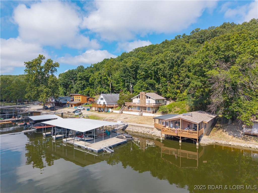 Incredible views with two beautiful homes that set the stage for this one-of-a-kind property. This property has with 140 Feet of lakefront, 68'X40' Concrete Dock, 3 slips, large swim platform and swim ladder, 2 Boatlifts, dual PWC lift, as well as 2 more separate PWC lifts,It is like having your own resort. New windows and tile floors have just been installed and the wonderful covered deck that sits out over the water is absolutely beautiful. Potentially, both houses can be used as vacation rentals providing an excellent income. The large private cove is wonderful for swimming, with all the Lake activities. All the popular places to go on the lake are close by water as well as by road. Great shopping near by and all the nightlife and wonderful events the Lake has to offer. Again this is a one-of-a-kind property that has so much to offer with so much potential, can be used for private family homes or rental income. This is a must see!!!