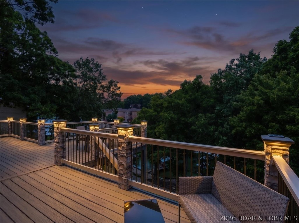Welcome to lakefront living in one of the most sought-after locations at the Lake of the Ozarks! Conveniently situated just off Bagnell Dam Blvd, this spacious waterfront home offers city water, city sewer, paved roads, and easy access to shopping, dining, and entertainment. Designed with comfort and functionality in mind, the home features 4 bedrooms, including a versatile bonus room that can serve as a 5th bedroom, media room, or office. The main-level living floor plan includes a generous primary suite, formal dining area, cozy kitchen with a breakfast nook, and an impressive great room highlighted by vaulted ceilings and expansive windows that showcase lake views. Multiple decks provide the perfect setting for relaxing or entertaining outdoors. A level driveway leads to the attached 2-car garage, while the massive walk-in crawl space offers approximately 1,500 square feet of additional storage or potential future living space. Outside, enjoy a 1-well dock and a gently sloping lakeside yard with plenty of room for a fire pit, outdoor seating, or your own waterfront oasis. This property is ready for you to start making Lake of the Ozarks memories this summer! DON'T MISS IT!!!