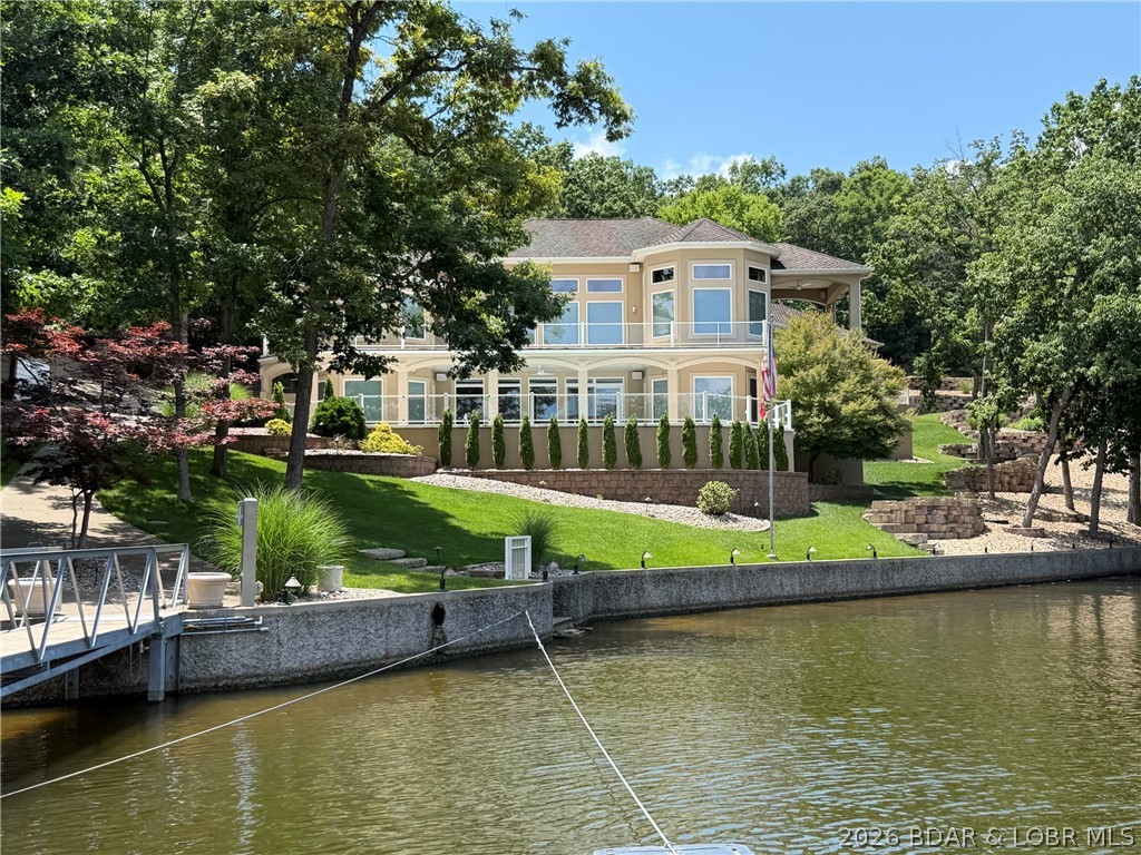 One of a Kind Property Located in the Village of Shawnee Bend. Stunning Lot with Gated Entry, Beautiful Landscaping, Golf Cart Path to the Dock, 209 ft of lakefront, Perfect Cove Location, TONS of parking PLUS 3 car attached garage, gentle Heated Driveway and an AMAZING home too! You will be impressed as soon as you walk in the door.... Soaring Ceilings with custom lighting, Gourmet Kitchen w/ custom Auburn Cherry Cabinets, Granite Countertops, Radiant Heat 18" Travertine Marble Floors throughout home, Spacious Primary Suite with luxurious bathroom (jetted Tub, Oversized Walk in tiled shower & Huge walk in closet), 4 Guest Bedrooms on Lower Level, Lower Level Famliy Room with Wetbar & screen projection theater & Sound System, Covered Deck and Open Deck on Main level PLUS covered Patio & Open Patio from lower level... you walk straight out to the pool area! Pool is Heated too.  The Concrete Dock was custom Built and allows plenty of room to entertain or just relax on the dock. A nice lakeside stone patio with firepit allows for year round enjoyment! Home has a state of the art electronics system and so much more. Hurry.. this one won't last long!