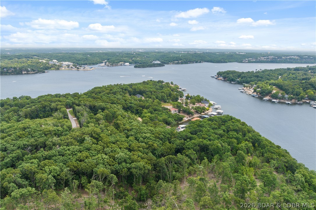 PRIME LAKEFRONT DEVELOPMENTOPPORTUNITY | 9.26 ACRES | 1,250’ OF SHORELINE! An extraordinary & increasingly rare offering at the 26 MM in Sunrise Beach—this remarkable 9.26-acre lakefront property boasts approximately 1,250 feet of pristine shoreline, creating a commanding presence on the water w/panoramic, unobstructed views. Tucked away in a protected cove with calmer waters, the setting delivers peace & privacy while remaining just minutes from premier dining, shopping, & entertainment. Positioned just prior to an established enclave of high-end lake homes, this R-1 zoned tract presents exceptional versatility. Ideal for a luxury private estate, a legacy family compound, or thoughtfully planned residential development, the property offers both road & water access, simplifying future construction & enjoyment. Large, buildable lakefront parcels of this size & shoreline depth are exceptionally scarce in today’s market, making this a standout opportunity for developers. Whether your vision is a signature lakefront residence or a strategic investment in one of the lake’s most desirable corridors, this property delivers location, scale, & unmatched potential at the Lake of the Ozarks.