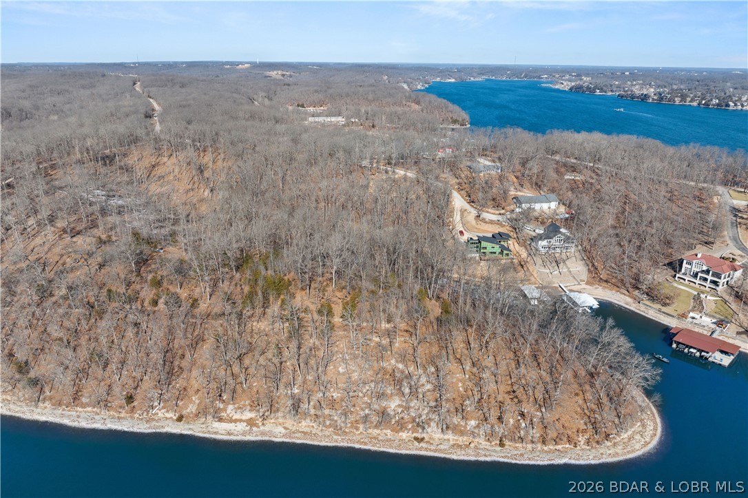 PRIME LAKEFRONT DEVELOPMENTOPPORTUNITY | 9.26 ACRES | 1,250’ OF SHORELINE! An extraordinary & increasingly rare offering at the 26 MM in Sunrise Beach—this remarkable 9.26-acre lakefront property boasts approximately 1,250 feet of pristine shoreline, creating a commanding presence on the water w/panoramic, unobstructed views. Tucked away in a protected cove with calmer waters, the setting delivers peace & privacy while remaining just minutes from premier dining, shopping, & entertainment. Positioned just prior to an established enclave of high-end lake homes, this R-1 zoned tract presents exceptional versatility. Ideal for a luxury private estate, a legacy family compound, or thoughtfully planned residential development, the property offers both road & water access, simplifying future construction & enjoyment. Large, buildable lakefront parcels of this size & shoreline depth are exceptionally scarce in today’s market, making this a standout opportunity for developers. Whether your vision is a signature lakefront residence or a strategic investment in one of the lake’s most desirable corridors, this property delivers location, scale, & unmatched potential at the Lake of the Ozarks.