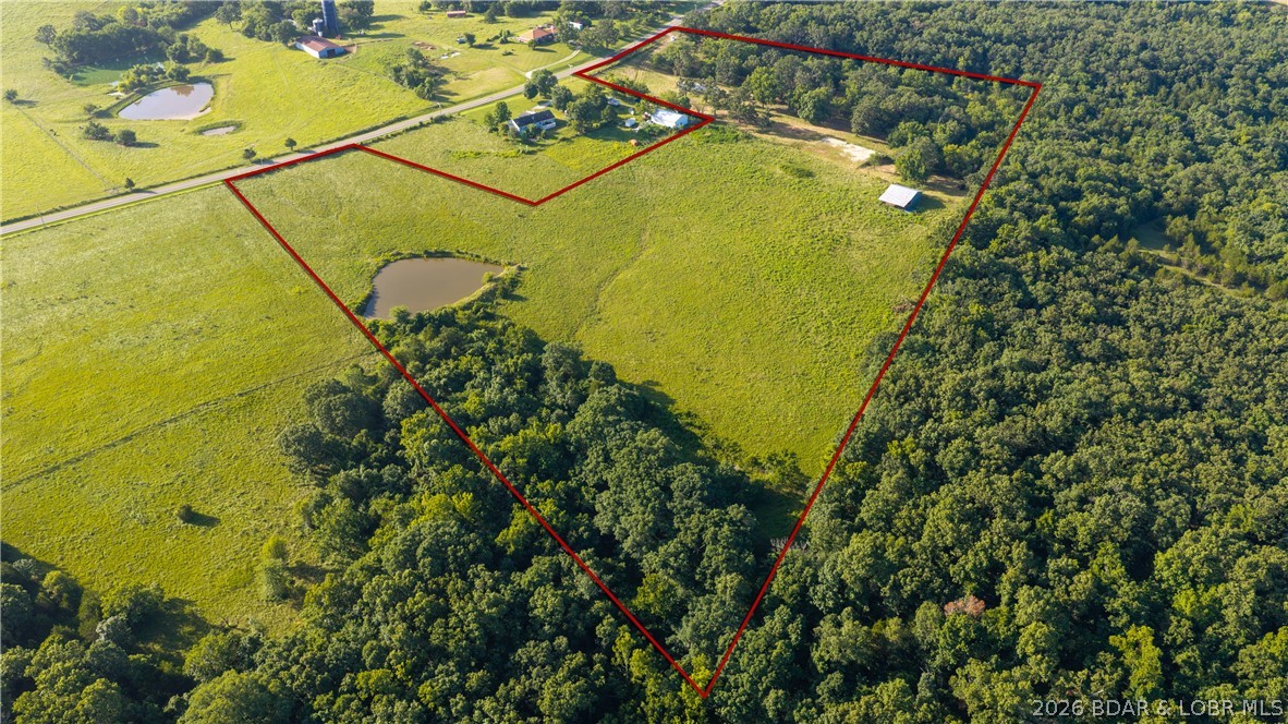 A rare opportunity to own 22.06 acres in the highly sought-after School of the Osage district! Offering a perfect blend of privacy and convenience, this property is located just 15 minutes from town with paved roads and highway access the entire way. Featuring mostly open pasture ground, the land provides endless possibilities for a private estate, hobby farm, or future development. Survey of the land is on file. The property includes two open barns, a gated entrance, and an established gravel driveway, allowing immediate access and functionality. A picturesque pond measuring just under half an acre adds to the charm and usability of the land. Enjoy the peaceful feel of small-town living while remaining close to all the shopping, dining, entertainment, and recreation the Lake of the Ozarks has to offer. Acreage of this size and quality in School of the Osage is increasingly difficult to find—don't miss your chance to make it yours.