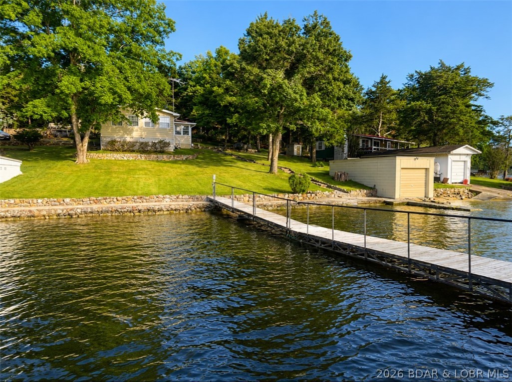 Welcome to your own affordable slice of Lake of the Ozarks! Nestled in a fantastic waterfront location near Coffman Beach Access, this charming 1-bedroom, 1-bath lakefront home offers incredible deep-water frontage, breathtaking sunset views, and the perfect setting for weekend escapes or peaceful full-time lake living.

Enjoy easy access to the water with a gentle sidewalk leading from the home directly to the private dock, making lake days effortless. The property also features a boat garage, giving you convenient storage for all your lake toys, and best of all—no HOA.

This home has great bones and endless potential. This is a wonderful opportunity to personalize a lakefront property and make it your own without paying premium waterfront prices.

Whether you're looking for a cozy getaway, an investment opportunity, or an affordable way to enjoy lake life, this property checks all the boxes. With its unbeatable location, stunning views, deep water, and exceptional value, opportunities like this don't come around often!