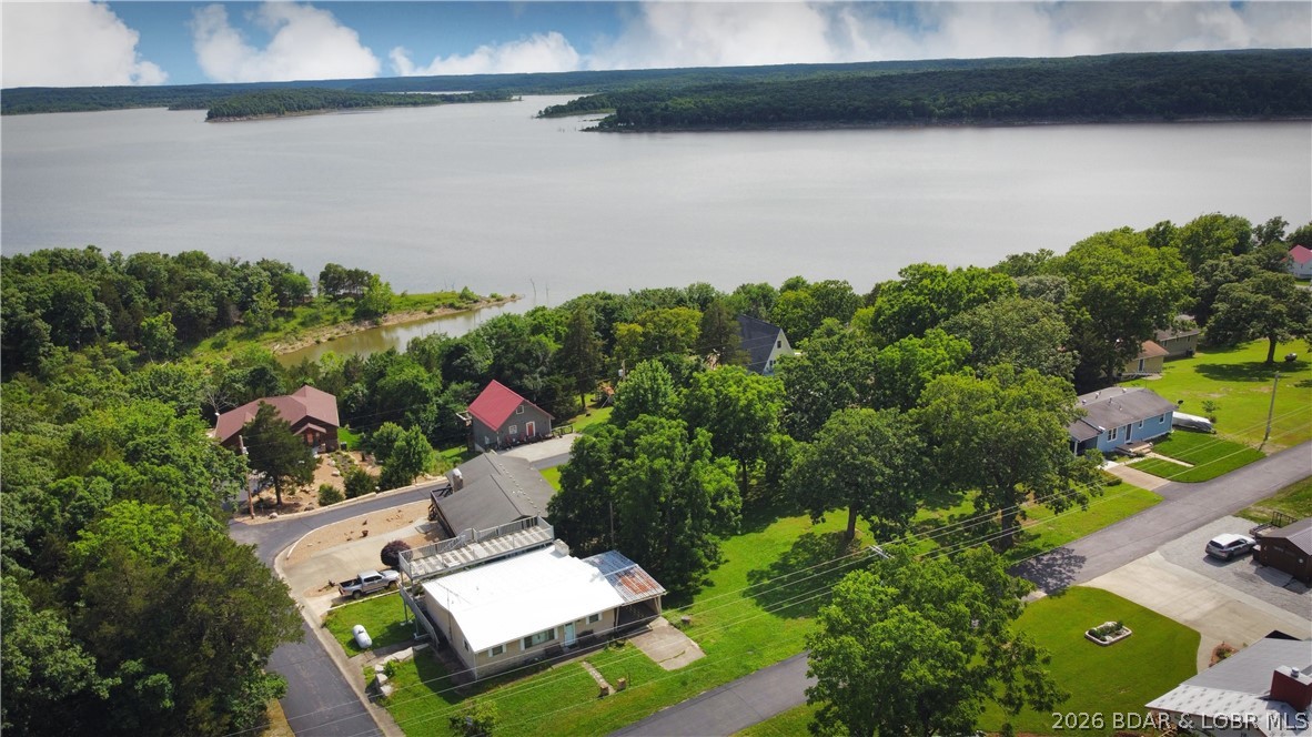 Super sought out location on Truman Lake with additional lots, this 3-bedroom home located in the highly desirable Pom Osa Heights neighborhood with convenient community boat access. Just down the road from the community boat ramp, this property offers easy access to fishing, boating, and lake recreation. The home features a spacious sunroom filled with natural light and a large fireplace, creating a warm and inviting atmosphere year-round. A unique multi-level deck provides excellent outdoor living space and captures beautiful views of Truman Lake—perfect for relaxing or entertaining. Large, additional lots offer an opportunity to build the perfect shop for all your toys and tools! Located less than 20 minutes from Warsaw and under 2 hours from Kansas City, this property offers a great balance of peaceful lake-area living with convenient access to nearby amenities. Don’t miss this opportunity—schedule your private tour today!