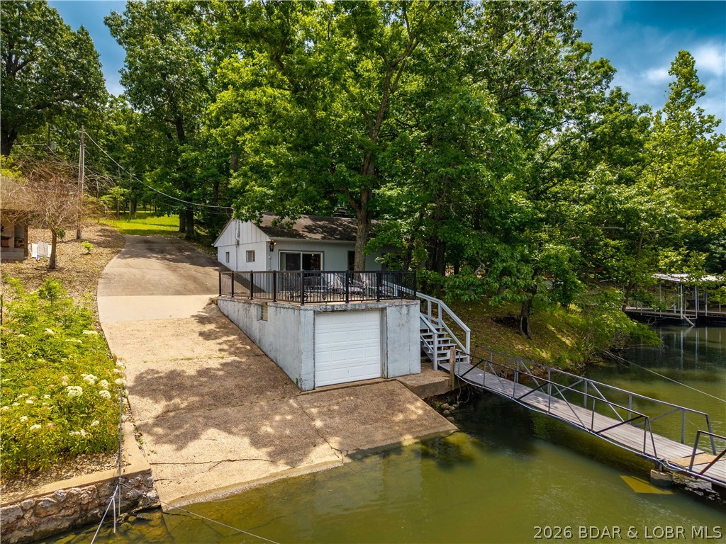 This is one of those homes that's almost impossible to find anymore - an affordable lakefront home with your own boat ramp, boat house, and large private dock. Nestled in a no-wake cove in Sunrise Beach, this charming 2-bedroom, 1-bath home offers the ideal Lake of the Ozarks lifestyle with zero steps to the water and deep water year-round. Whether you're looking for a weekend retreat, investment property, full-time lake home, or land for development, this property offers endless possibilities. Enjoy the convenience of your own permitted boat ramp, making launching and retrieving your boat a breeze. The lakeside boathouse provides valuable storage while also serving as the perfect waterfront patio space for entertaining, relaxing, or enjoying peaceful lake views. A private dock offers easy access to days spent boating, swimming, and fishing. Set on a gentle lot in a desirable neighborhood, this property is special not only for what it is today, but also for its future potential. The usable flat lakefront and access to the water makes the potential of this property incredibly unique. Come see it for yourself before it's too late!