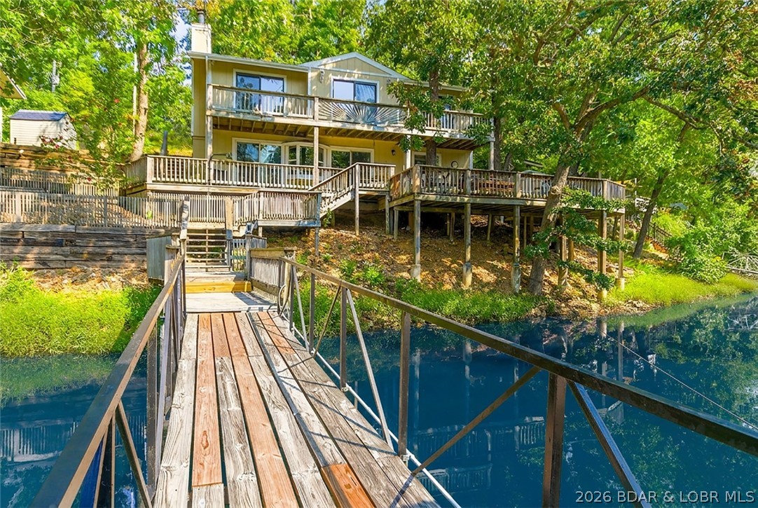 THIS IS IT! Lakefront living at its finest!! This beautifully updated and completely turnkey home features a spacious kitchen & dining area where you'll never run short on cabinet space or seating, a large family room, tons of outdoor entertaining area all with stunning lake views. Expansive deck leads to the dock with a swim platform which is great for entertaining and relaxing by the water, swim ladder and 10x24 slip. The primary suite offers an en-suite bath, and an attached deck that spans the entire main level. Whether you're looking for a full-time residence or vacation getaway, this home has it all. Located at the 8MM and close to some of the best restaurants Lake of the Ozarks has to offer!! Paved circle drive with parking for at least 4 cars. New septic in 2023. Schedule your private showing today and start living the lakefront lifestyle!