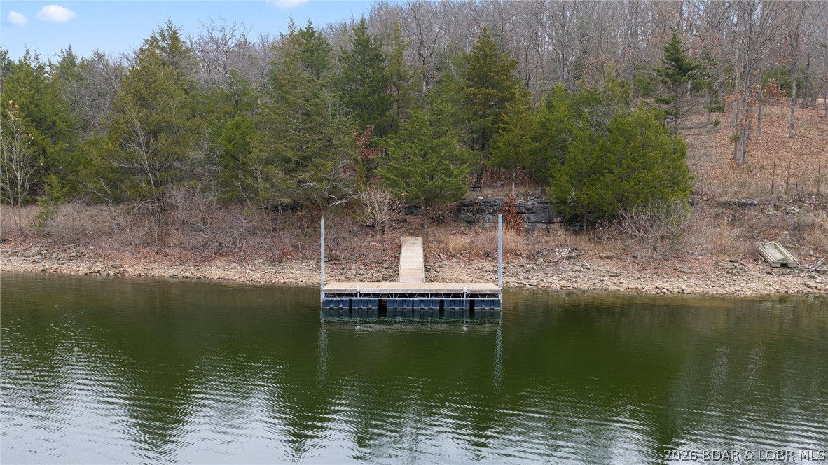Experience the best of peaceful living and easy lake access on this scenic 0.21-acre waterfront lot. With a gentle slope leading down to the shoreline, the property showcases calm water views and a perfect backdrop for your future retreat. A convenient day dock makes it simple to swim, kayak, or head out on the lake whenever you like. Whether you’re dreaming of a cozy escape or building a custom home, this property offers a unique chance to enjoy lakeside living in a quiet, natural setting.