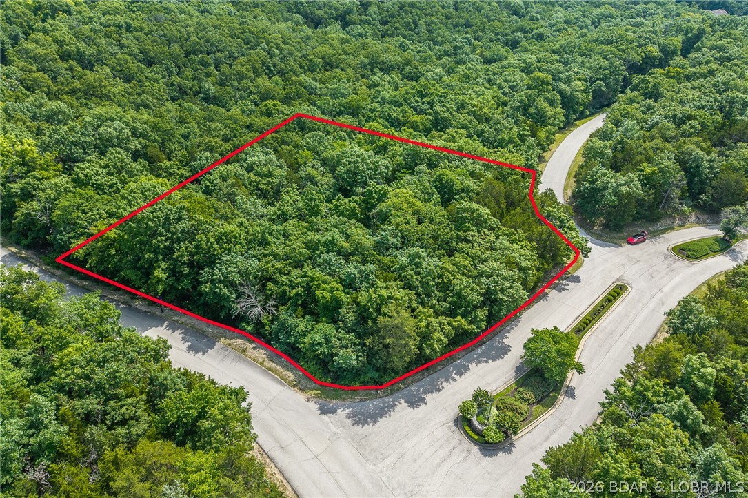 Surrounded by mature trees and natural Ozarks beauty, this wooded lot at The Villages at Shawnee Bend offers a peaceful, private setting within one of Lake of the Ozarks’ most distinguished communities. From the moment you arrive through the grand waterfall entrance, the neighborhood’s upscale character is clear. Residents enjoy access to a beautifully appointed clubhouse, resort-style community pools, championship tennis courts, and pickleball facilities, along with parks, playgrounds, and marina access. Paved roads and underground utilities make building seamless while preserving the natural landscape. Ideal for a custom home or lake retreat, this wooded homesite blends serenity, luxury, and an active lake lifestyle.