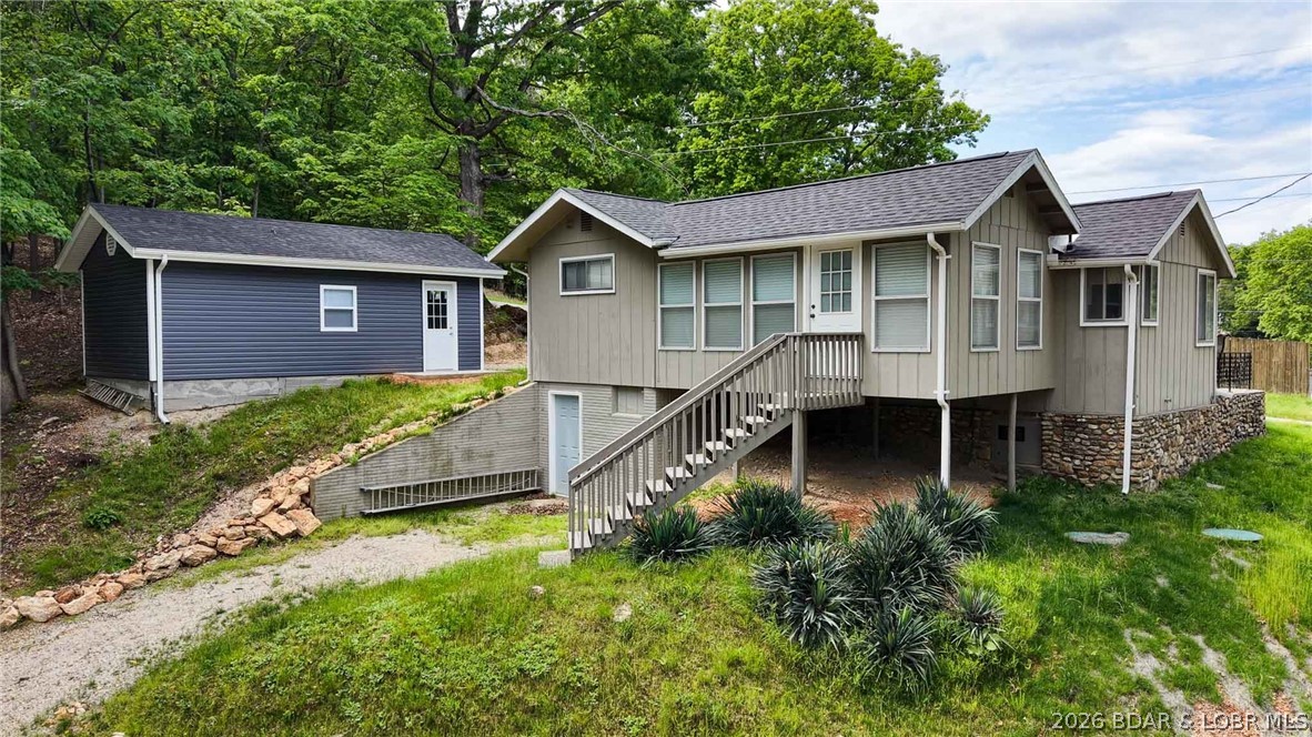 DON'T BUY A CONDO! BUY THIS INSTEAD! This home offers WATER FRONTAGE, PRIVATE DOCK, and GARAGE! This could make a great starter place at the lake for a full timer or vacationer!  Escape to this charming retreat nestled by the water's edge, TURNKEY! Great location at the 10MM. This delightful home offers a private dock, 2 bedrooms, 1 bathroom, & charming living area with lake views. It's perfectly sized for cozy getaways. Fully furnished, this property provides instant relaxation from the moment you arrive. The property has a community boat ramp in addition to a private dock with a remote boat lift just steps from the back deck. The hardy board siding and newer roof ensure this will be a low-maintenance property for years to come! With no HOA or rental restrictions, this property provides a great investment opportunity or family getaway at the lake! Now is the time to take the plunge on your very own piece of paradise at Lake of the Ozarks!  '94 Larson RXI dual prop, V8 boat & trailer in good condition is available to purchase with the home for additional. $7,500.