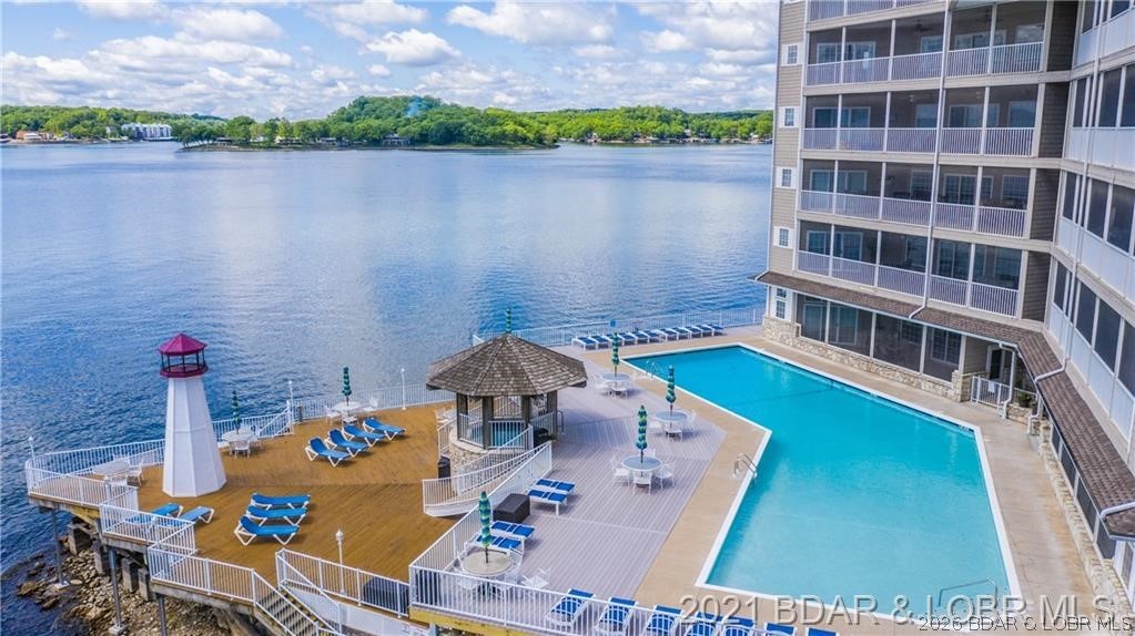 A sense of beauty & peaceful serenity is abundant, looking out on a point that overlooks Lake of the Ozarks from the wide panoramic view of the Large screened-in-deck, setting the stage for one of the most sought after locations at the Lake. Luxury living at the highest level is what makes this unit so impressive. (ELEVATOR just steps away) Open floor plan, Master suite has wonderful views, access lighting in the ceiling, Jacuzzi tub, walk-in shower & and walk-in closet. 2nd suite has its own bath with lake views and nearby a 3rd large bedroom with full bath. There is a dining area, Large living room, with recess lighting, large fireplace and ceiling fans. Well designed Kitchen with lots of custom cabinets, beautiful backsplash, granite countertops, custom lighting and views of the Lake. Off the kitchen is a large laundry room with a counter for folding, sink and more cabinets. Lighthouse Pointe amenities offer gated entrance, security, playground, and lakefront community pool and hot tub. Also included in the sale is 12x32 BOAT SLIP, Boat lift and a PWC SLIP. Views of the Lake can be seen in almost every room, see this beautiful unit soon and start enjoying the Lake!!!!