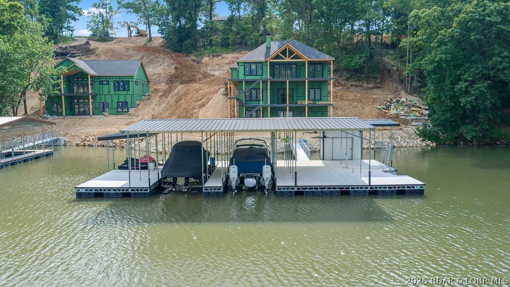 Experience lakefront living at its finest in this stunning new construction luxury home featuring 6 bedrooms, 6.5 bathrooms, and three expansive levels of thoughtfully designed living space. Every bedroom is an en suite, offering unparalleled comfort and privacy for family and guests alike. Perfectly positioned to capture breathtaking lake views, this exceptional property boasts a massive dock, direct lake access via wraparound exterior stairs, and a spacious screened upper deck designed for year-round enjoyment. The open-concept floor plan seamlessly blends elegant finishes with modern functionality, creating the ideal setting for entertaining and relaxation. Additional premium features include wiring for two electric vehicle charging stations, hot tub readiness, and high-end construction throughout. Whether you're seeking a luxury full-time residence, vacation retreat, or investment opportunity, this extraordinary lakefront home delivers the ultimate waterfront lifestyle. Located on the 35 MM of Lake of the Ozarks. NO HOA! Call today for a private showing!