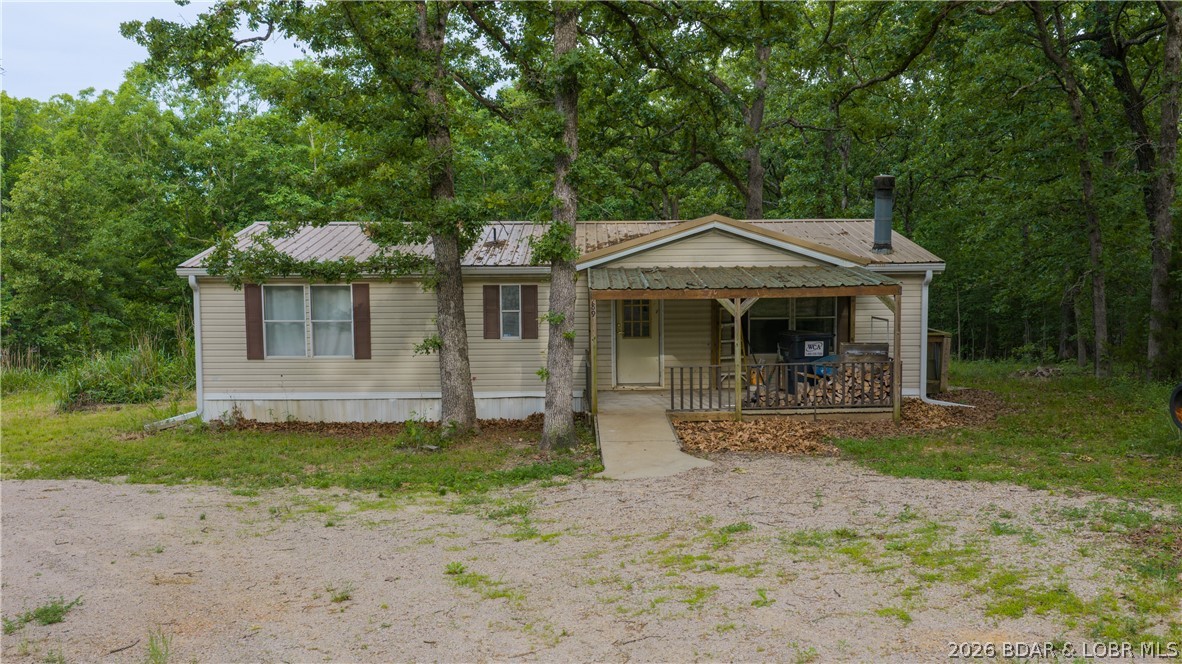 Rare opportunity to own 6.6 acres of beautifully wooded privacy at Lake of the Ozarks! Located between Osage Beach & Camdenton & just 2.6 miles from Hwy 54 down A Rd, this unique property offers two adjoining parcels w/endless possibilities for your dream home, private retreat, investment property, or family compound. Both parcels feature established homesites w/shared well access & electric already installed. One 3.02-acre tract includes a modular home w/a new septic system that just needs a few repairs & your personal touch to transform it into your own secluded piece of heaven. The adjoining 3.6-acre parcel features another homesite w/septic & a mobile home currently on the property that is in rough condition & may need to be removed unless you’re handy & ready for a project. Enjoy peaceful country living surrounded by nature while being just minutes from shopping, dining, entertainment & all the Lake Life attractions the area is known for. With plenty of room to build a garage, workshop, man cave, additional home, or simply create the ultimate getaway, the possibilities here are endless. Whether you’re looking for privacy, space, or investment potential, this property delivers!