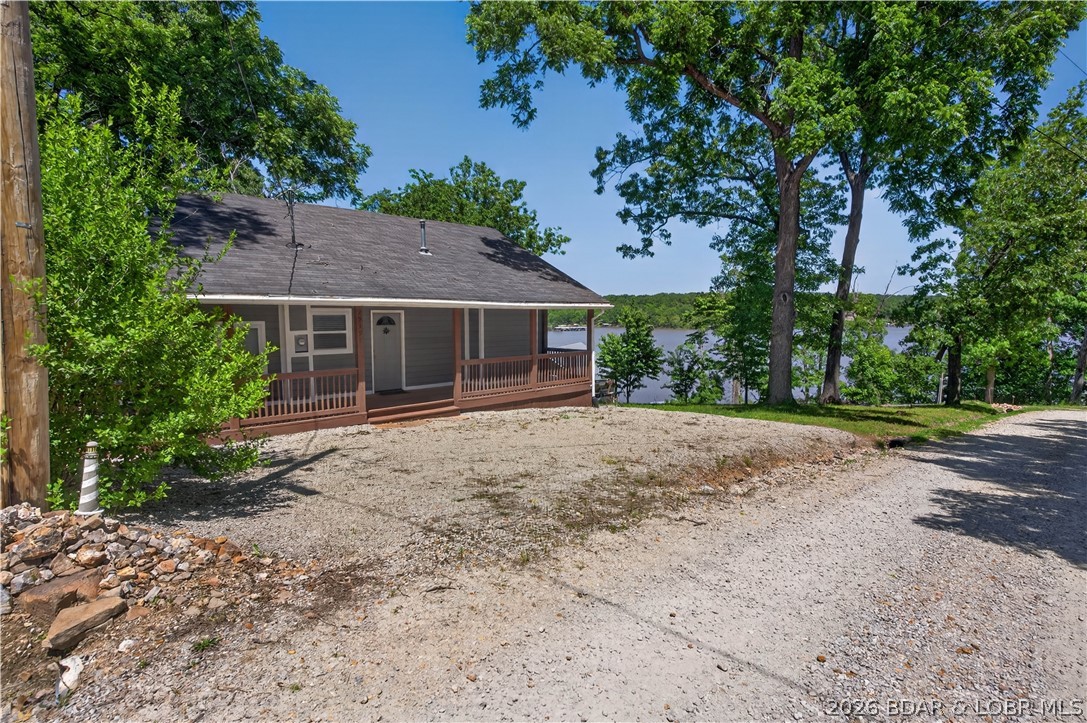 Take a look at this beautiful 4-bedroom, 2-bath home at the Lake of the Ozarks! This home perfectly situated with the best main channel views with a dock conveniently just a short walk away in a quiet no-wake cove with deep water access. Designed with lake living and entertaining in mind, this property features two spacious bedrooms on the main level, along with a large living room and open kitchen that make hosting family and friends easy and enjoyable. Upstairs offers two additional oversized bedrooms and a full bath, providing plenty of room for guests. Step outside and relax on the screened-in porch while taking in the lake views or enjoy the sunshine from the open deck area! The partially fenced backyard offers great space for pets, gardening, or outdoor activities with the little ones. A detached garage provides excellent storage for lake toys, tools, and equipment. Conveniently located just off paved roads and tucked away in a low-traffic cove, this property offers both privacy and easy access. Priced to sell—don’t miss your chance to enjoy lake life at its finest. Call today to schedule your showing!