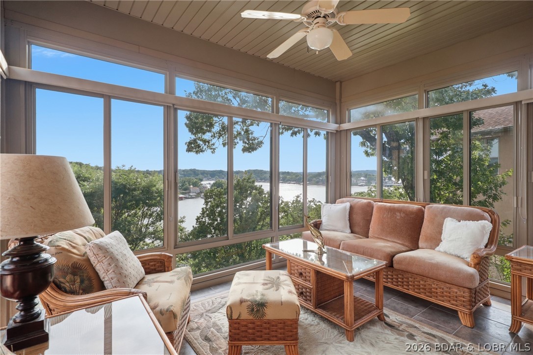 Set high above the water's edge, this exceptional Bella Terra villa showcases lake views that seem to stretch forever. The crown jewel of the home is the remarkable four-seasons room, where floor-to-ceiling windows create a front-row seat to the ever-changing beauty of the Lake of the Ozarks. From quiet mornings with coffee to vibrant sunsets reflecting across the water, every season becomes part of the experience. Located in the gated Bella Terra Villas, this beautifully furnished 3-bedroom, 3.5-bath home offers luxury living with stunning architecture, soaring ceilings, abundant natural light, and breathtaking lake views throughout. The kitchen features custom cabinetry, granite countertops, stainless steel appliances, and an open layout ideal for entertaining. The spacious primary suite includes a custom built-in closet, while the lower level offers a second living area with 9-foot ceilings and a granite wet bar. Outside, enjoy the expansive deck, covered patio, heated 2-car garage, lake access, community pool, and a 10x32 boat slip. With numerous upgrades already completed and luxury finishes throughout, all that's left to do is arrive, relax, and start enjoying lake life.