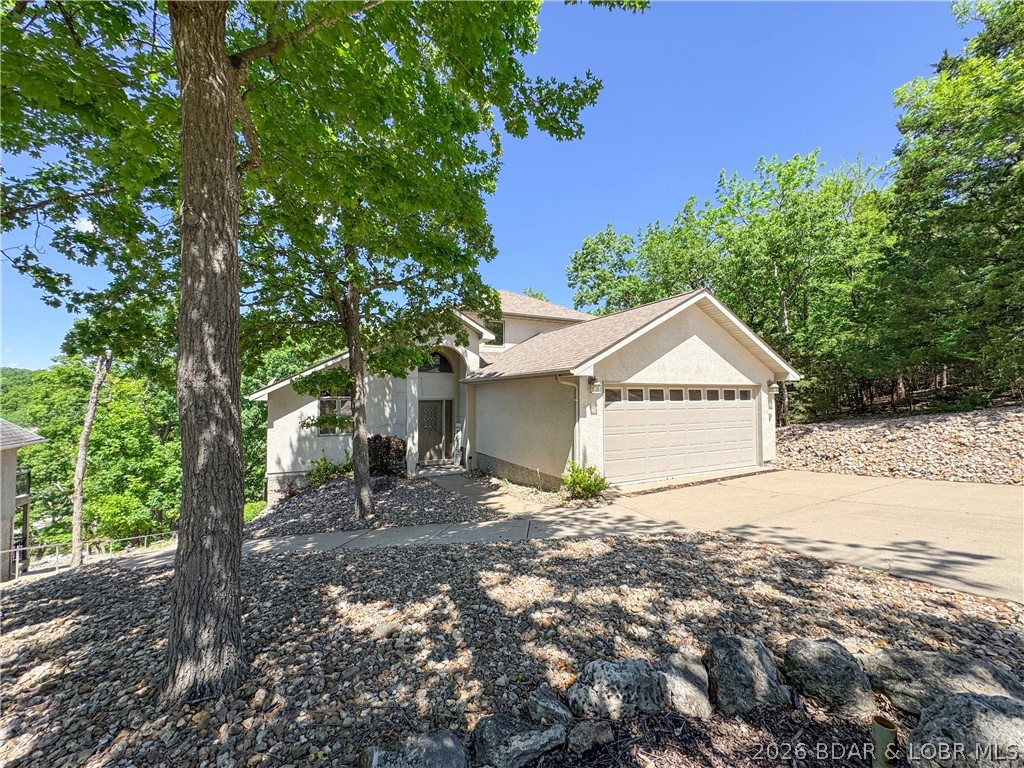Deep water. Cove protection. Private dock. This rare 5-bedroom lakefront retreat delivers the features buyers wait for — and it’s now priced to move. This 5BR/3BA/2 half-bath, furnished home at Lake of the Ozarks features granite countertops, abundant wood cabinetry, great pantry space, two living areas, sauna, hot tub, and a golf cart path to the dock area. Ideal for full-time living, vacationing, or investment potential. Need even more...there is a second lot included for your additional wants or needs. Enjoy protected cove waters without sacrificing quick access to the main channel. This home shows off with main-level living. The kitchen is ideal for the chef in your life with abundant cabinet space and upgraded appliances. The over-sized Primary suite offers double closets and a large walk-in spa-like shower. The upper level is home to two large bedrooms with Jack N Jill bath access. Stroll to the lower level and enjoy an additional living area with two more bedrooms and another full bath. The two decks connect easily with the spiral staircase. Small fenced area for your furry friends. The gentle driveway has great parking that attaches to the golf cart path for easy access.