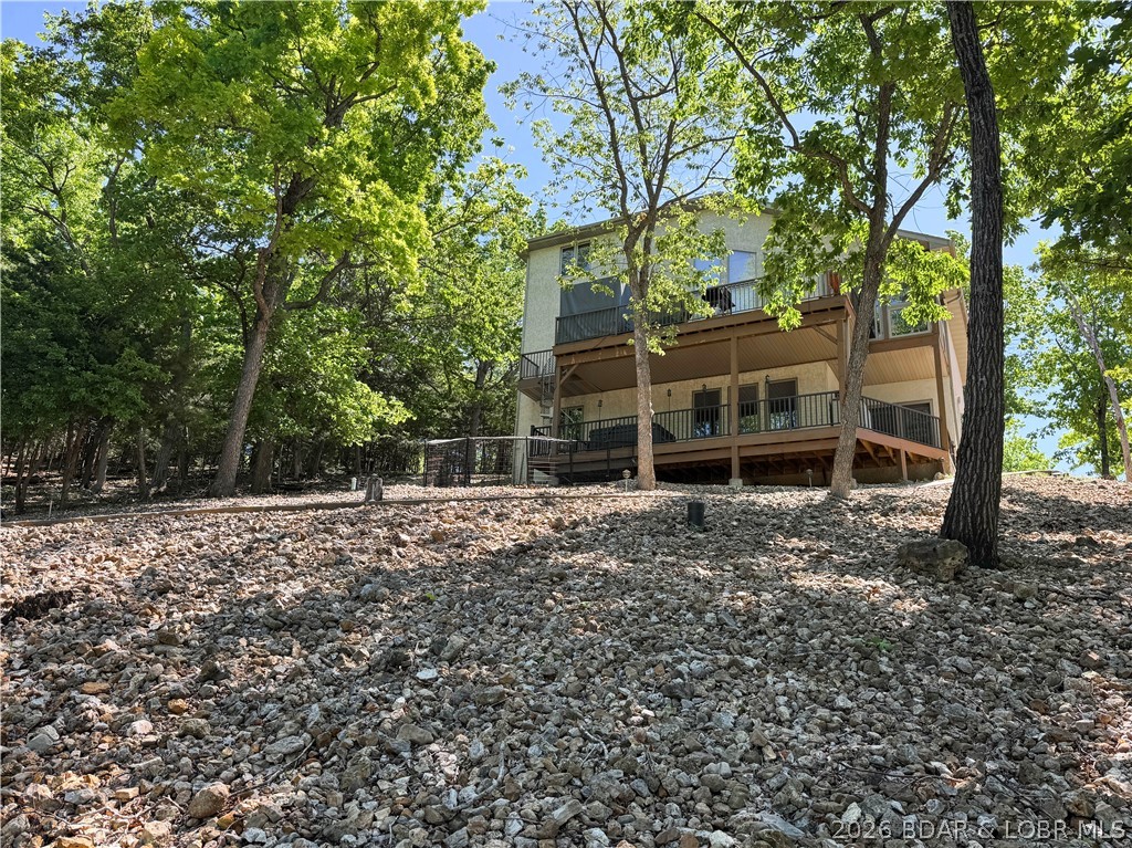 Deep water. Cove protection. Private dock. This rare 5-bedroom lakefront retreat delivers the features buyers wait for — and it’s now priced to move. This 5BR/3BA/2 half-bath, furnished home at Lake of the Ozarks features granite countertops, abundant wood cabinetry, great pantry space, two living areas, sauna, hot tub, and a golf cart path to the dock area. Ideal for full-time living, vacationing, or investment potential. Need even more...there is a second lot included for your additional wants or needs. Enjoy protected cove waters without sacrificing quick access to the main channel. This home shows off with main-level living. The kitchen is ideal for the chef in your life with abundant cabinet space and upgraded appliances. The over-sized Primary suite offers double closets and a large walk-in spa-like shower. The upper level is home to two large bedrooms with Jack N Jill bath access. Stroll to the lower level and enjoy an additional living area with two more bedrooms and another full bath. The two decks connect easily with the spiral staircase. Small fenced area for your furry friends. The gentle driveway has great parking that attaches to the golf cart path for easy access.