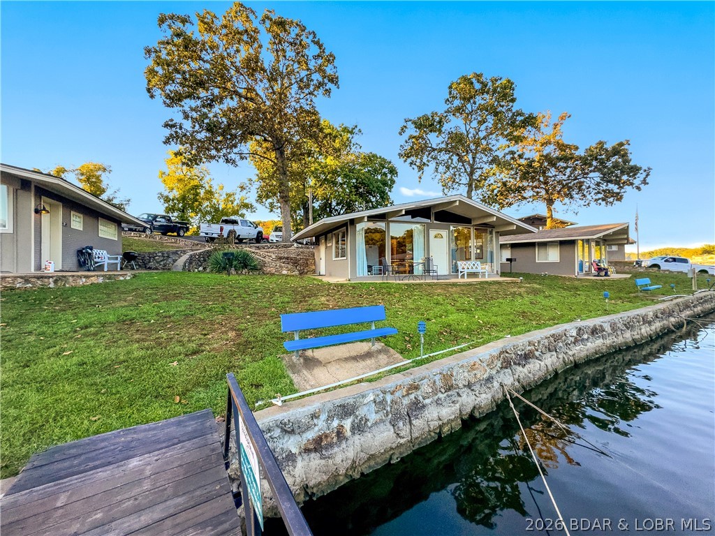 BASS POINT RESORT Lake Cabin with a Dock Slip. Great Rental History and comes Turn-Key ready to enjoy. All the benefits to owning your Lake Home. Close to the Community Pool, 2 Bedroom/1 Bath, Vaulted Ceilings, Laminate Flooring in Bedrooms, lots of Lake View Windows and a Lake Front Patio to enjoy the Lake. Easy walk to the Dock Slip & community lakefront. Amenities include Laundry Facilities, Club House with Rec Room for gatherings, Arcade, 2 Pools (1 indoor & 1 outdoor), Tennis, Pickleball & Basketball Courts, Playground, Swim Dock, Boat Ramp, outside Fire Pits and much more. Home is on a successful Rental Program for extra income. Classic "Lake Cabin" less expensive than a Condo & doesn't have the high HOA fees.