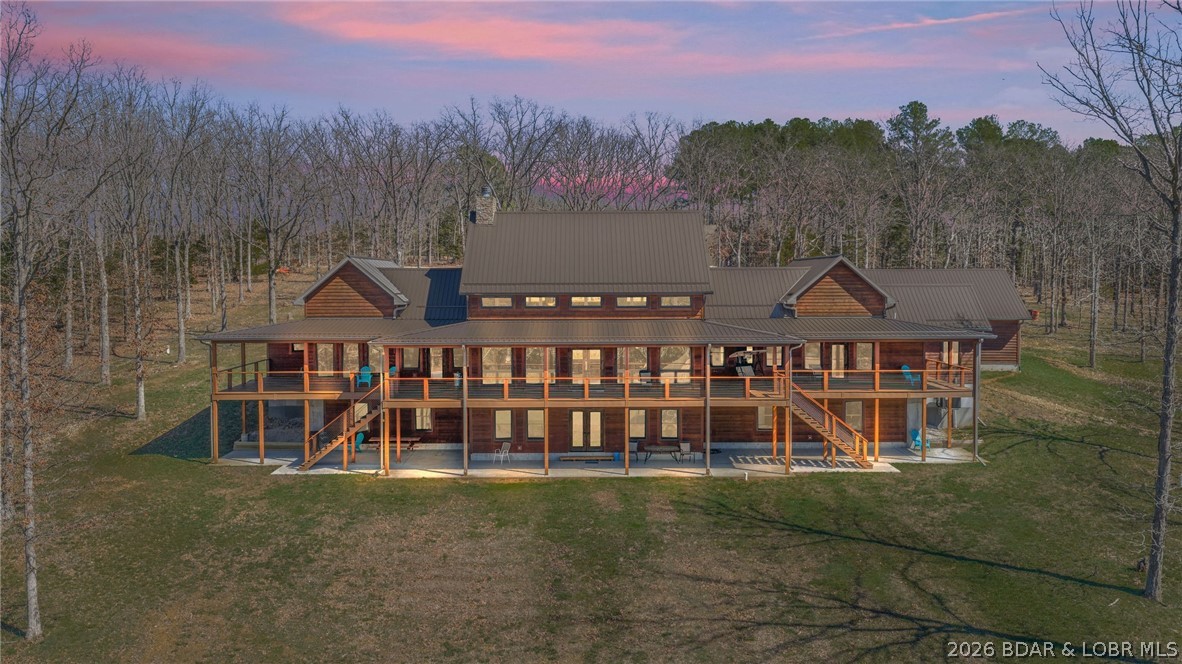 This exceptional 105± acre Ozark ranch offers a rare blend of scenic beauty, quality improvements, and a lodge-style home reminiscent of Yellowstone or Big Cedar. The property features fenced pastures bordered by timber, a picturesque 1± acre stocked pond, and a wet-weather creek winding through the valley floor, creating a setting that is both functional and beautiful. Ideal for an equestrian estate, recreational retreat, or private family getaway.
Improvements include automatic drinkers, a 30x56 hay barn with water and solar lighting, a 60x60 horse barn with water and 100-amp service, a 28x36 detached garage with 100-amp electric, and a 40x80 insulated shop with 200-amp service—providing excellent infrastructure for livestock, equipment, and hobbies.
The 3 bedroom, 3.5 bath lodge-style home features vaulted ceilings, rich wood finishes, knotty alder cabinetry, granite countertops, and a marble fireplace hearth anchoring the main living space. Each bedroom has direct access to the covered wraparound deck overlooking the valley below, offering peaceful views in every season.
Private and serene, yet conveniently located with quick access to Interstate 44.