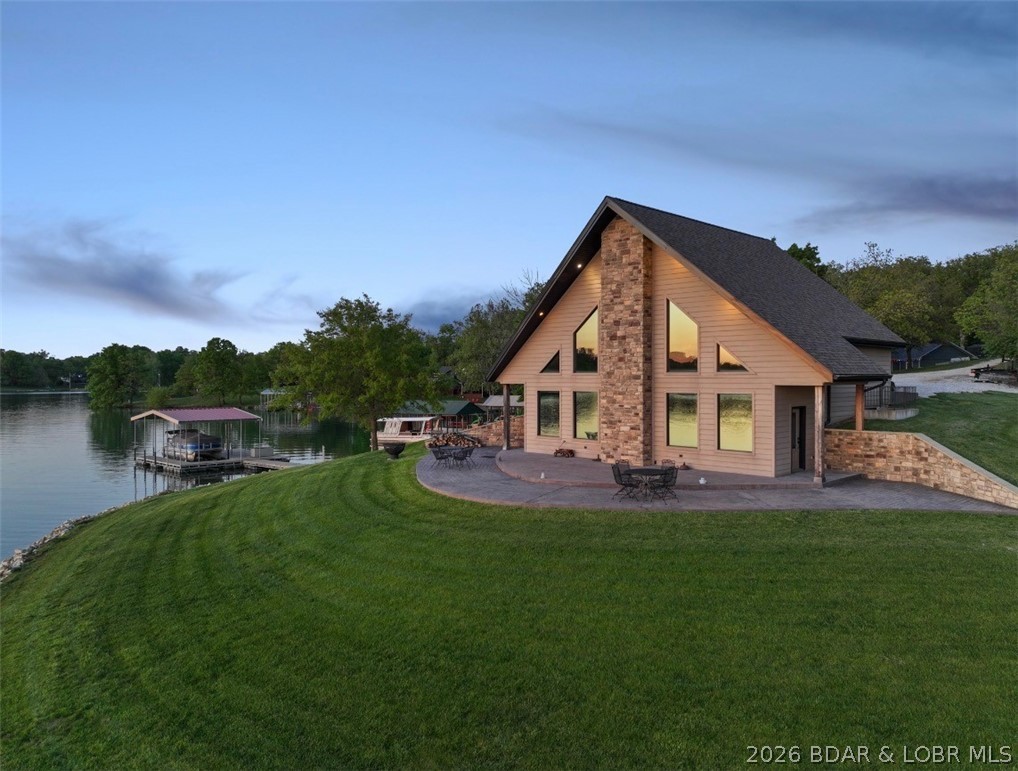 Discover lakeside living at its finest in this pristine waterfront home, perfectly positioned on two exceptional lots with 342 feet of shoreline. Enjoy breathtaking views from your private patio—ideal for outdoor dining, relaxing in the sun, or watching stunning sunsets. Built in 2015, this all-electric home features durable fiber cement siding, seamless gutters, a one-year-old roof, and fiber internet availability. The bright, open layout is filled with natural light from large windows on the main floor and loft. Outside, a spacious yard, rocked seawall, and one-slip metal-framed dock with swim platform and concrete flooring make lake access effortless. The community offers resort-style amenities including a clubhouse, pool, golf course, beach, parks, volleyball, pickleball, and campgrounds, plus a private convenience store nearby. Whether you’re seeking a peaceful getaway or your forever home, this property delivers the ultimate lakefront lifestyle.