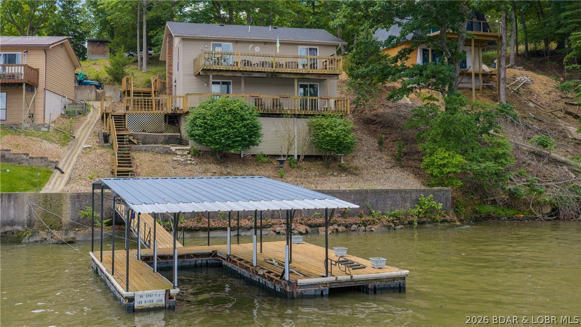 Welcome to lake life in this warm and inviting lakefront home offering a very generous dock envelope with 90 feet of shoreline in a convenient location just inside Linn Creek Cove—only minutes from all the dining, shopping, and amenities of Camdenton. Facing mostly Northeast, enjoy peaceful mornings and beautiful sunrises over the lake from the expansive covered decks. Offering 3 bedrooms plus a versatile bonus room perfect for a non-conforming 4th bedroom, office, workout room, or bunk space, there is plenty of room for family and guests. The main level features the living area and primary suite, while the lower level offers additional guest accommodations and a second living space ideal for gathering after a fun day on the water.vTwo oversized covered decks span the entire width of the home—one on each level—creating wonderful spaces to relax, entertain, and enjoy the lake views. Moderate topography, ample parking, and an ideal location by land and water add to the appeal. By boat, enjoy quick access to local favorites including The Cave, Captain Ron’s, NautiFish Rum Bar, and Larry’s on the Lake. Buy now, update to your style, and start making lake memories this boating season!