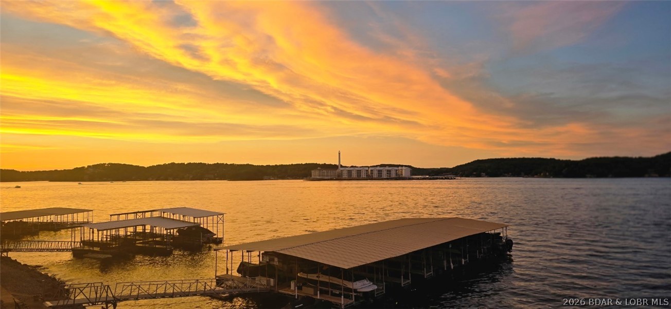 Offered at a new and improved price! Experience the ultimate “wow” moment the instant you step inside this beautifully maintained, turnkey lakefront retreat. Ready for short-term rentals, this 2-bed, 1-bath condo offers incredible versatility as a lucrative investment, low-maintenance getaway, or refined weekend escape. Panoramic water views greet you as you cross the threshold, delivering an immediate connection to the lake lifestyle. Just steps from the water, the outdoor amenities are an absolute dream for boaters. The included dock features a 10 x 24 boat slip equipped with a heavy-duty, remote-operated 4,000 lb Poly Lift, alongside 2 dedicated PWC spots. Inside open-concept layout maximizes the water views, beautifully accented by engineered hardwood floors & custom tile work. The property is offered truly turnkey & comes fully furnished—including multiple beds & a sofa sleeper—making it immediately ready for you or your rental guests. Exceptional pride of ownership is evident throughout, backed by peace-of-mind updates like the brand-new water heater (2024) & HVAC (2015). Completely move-in ready for the season, this rare waterfront gem is primed and ready for its next owner.