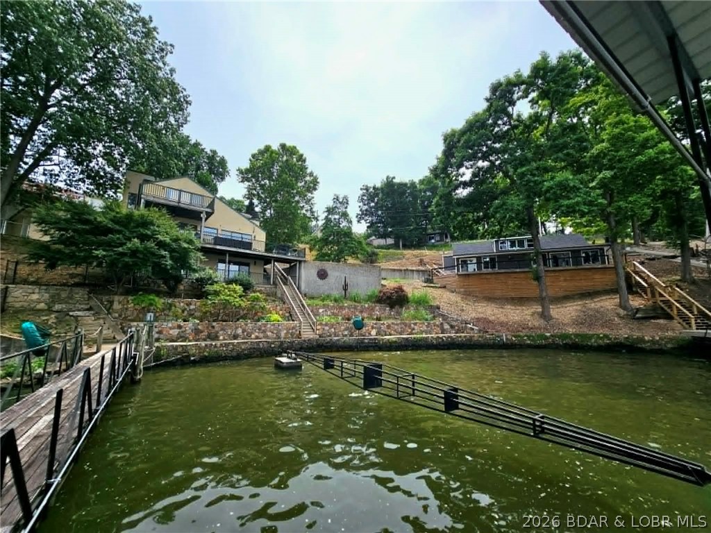 Two beautifully remodeled lakefront homes offering an incredible 300 feet of shoreline at the Lake of the Ozarks! This unique property features two private docks, a total of 9 bedrooms and 6 bathrooms, plus an additional second-tier lot for added flexibility and value. Located at the desirable 10-mile marker, you'll enjoy convenient access to popular waterfront restaurants, entertainment, and attractions. Whether you're seeking a lucrative investment property, vacation rental opportunity, family compound, or multi-generational retreat, this rare offering provides endless possibilities with exceptional lakefront living and income potential.