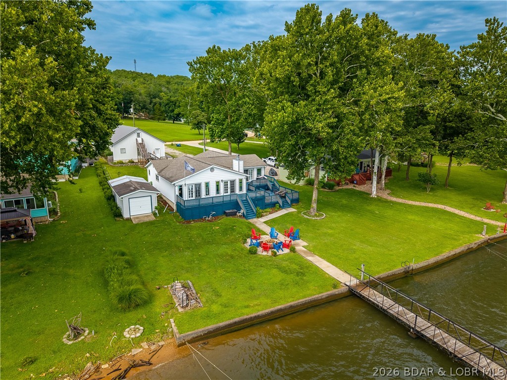 Hard-to-find one-level lakefront living at the 49-mile marker! This well-maintained 4-bedroom, 3.5-bath home offers the ease and comfort of main-level living with everything you need conveniently located on one level. The open-concept living, dining, and kitchen area creates a welcoming space to relax, gather, and take in the beautiful lake views.

Two bedrooms feature lake views, and the peaceful setting offers calmer water, less boat traffic, and views that are hard to beat. Just a few steps down from the home, a sidewalk leads directly to the large 3-well dock, making lake access easy and enjoyable.

The property also features a newer detached 4-car garage/shop with HVAC and additional living space above, offering great flexibility for guests, hobbies, storage, or workspace. Two storage/garden sheds provide plenty of room for gardening or store the lake toys, lawn furniture, and outdoor gear, helping keep the garage clean and clutter-free.

With one-level living, incredible views, a spacious dock, generous storage, and a peaceful lakefront setting, this is the lake home dream that is so hard to find!