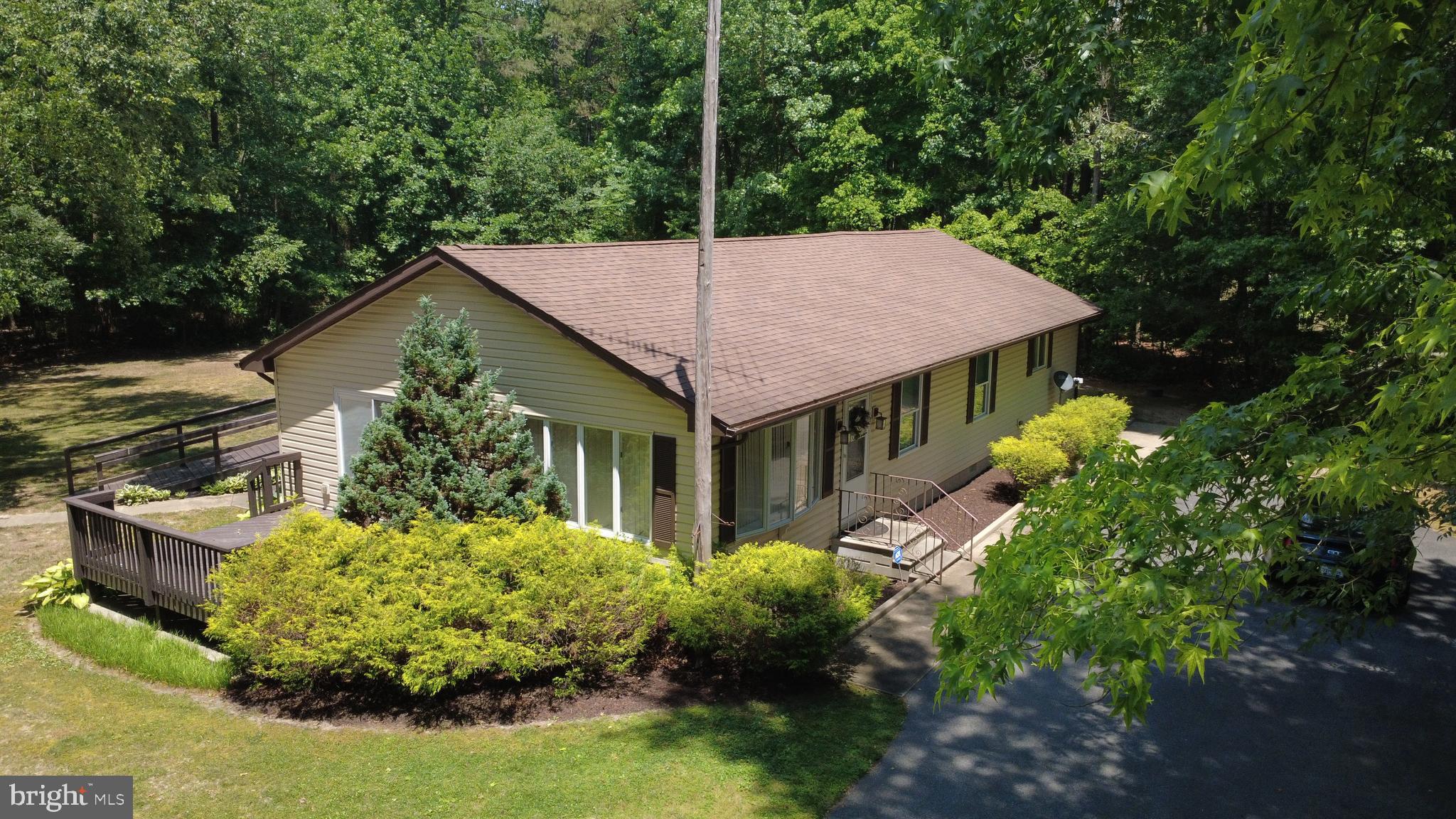 Single-level 3-bedroom, 2-bathroom ranch on a private wooded lot in Federalsburg, Maryland. The open-concept main living area connects a spacious living room with a ceiling fan to a dining space and a fully equipped kitchen featuring dark wood cabinetry, stone countertops, a tile backsplash, stainless steel appliances, a gas range, a French-door refrigerator, and a center island with breakfast-bar seating. Luxury vinyl plank and tile flooring run through the main living areas.
The primary suite offers an en-suite bathroom with a corner jetted soaking tub, a separate tiled walk-in shower, a double-sink vanity, and a large mirror. Two additional bedrooms include ceiling fans and share a second full bathroom with a tub-shower combination. A dedicated laundry room with a full-size washer and dryer adds everyday convenience.
Outside, a large wrap-around deck with railing overlooks the surrounding woods, ideal for outdoor entertaining and quiet mornings. The property includes a detached garage, storage shed/garage, and a private driveway set among mature trees. The wooded acreage delivers privacy and space rarely found at this price point.
Located in Federalsburg on Maryland's lower Eastern Shore in Caroline County, the home sits near Marshyhope Creek, downtown Federalsburg, and Route 313, with an easy drive to Seaford, Delaware and Cambridge for shopping, dining, and commuting. This move-in ready Federalsburg ranch combines single-level living, an updated kitchen, a primary bath, and outbuildings on a private wooded setting in Caroline County, Maryland 21632