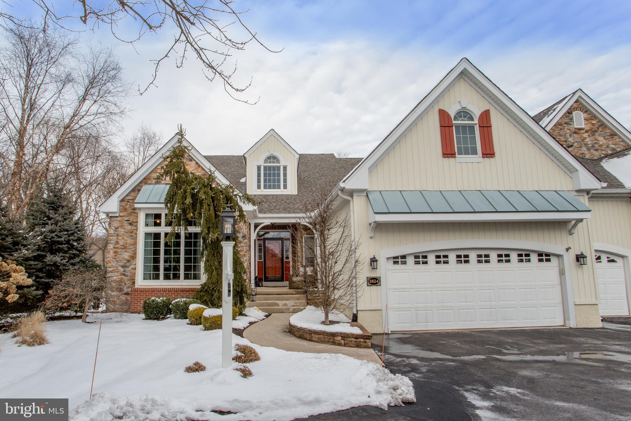 Rarely offered in Prestigious Stone Ridge is this Fabulous End Unit Carriage House backing to the preserved and wooded open space.  From the moment you arrive, you will realize you’ve found something special.  The front porch welcomes you into the two-story foyer, setting the stage for this gracious home with numerous upgrades. For the discerning buyer, let’s start with the dining room featuring an exquisite gold leaf ceiling treatment and Italian brass chandelier.  The plaster treatment on the walls in this room add to the high-end touches that were so thoughtfully executed in this home.  To the left of the foyer is the guest/secondary bedroom which is currently being used as an office, complete with a stone feature wall and tongue & groove wood ceiling for added style and warmth. The Great Room is complemented by a gas fireplace, custom-built-ins and a 12’ ceiling with exposed beams.  This space opens to the oversized gourmet kitchen complete with Sub Zero Built-in Fridge and JennAir Stainless Steel appliances. The hammered copper range hood is a showstopper! Adjacent to the kitchen is the full-length deck offering a natural gas grill for ease of use and a power awning for extra shade on sunny days.  The primary bedroom on the main level offers two walk-in closets with custom finishing systems and a spa-like bath with jacuzzi soaking tub, separate steam shower and dual vanities.  Also on this level is the laundry room with brand new washer and dryer. As you descend to the lower level, you will first notice the double-sided, floor-to-ceiling gas fireplace which delivers atmosphere to both the media space and the custom wet bar and wine storage wall.  You will love the privacy that the en-suite bedroom offers.  Additionally, this room walks out directly to the lower terrace which has been recently renovated creating  outdoor living room options for the next lucky homeowner.  Also on this level, is a gym, kitchenette area, as well as ample storage both finished and unfinished. New Roof December 2023. The two-car garage is heated and finished with an epoxy floor.  Finishing touches include the whole-house generator, whole-house speakers for multi-level entertainment and central vac.  This home and neighborhood provide turnkey, maintenance-free living and easy access to Peddler’s Village via the private walking path. Minutes to New Hope and Doylestown and easy access to commuter routes to NJ, NY and Philadelphia make this the perfect home and setting.  Welcome Home!