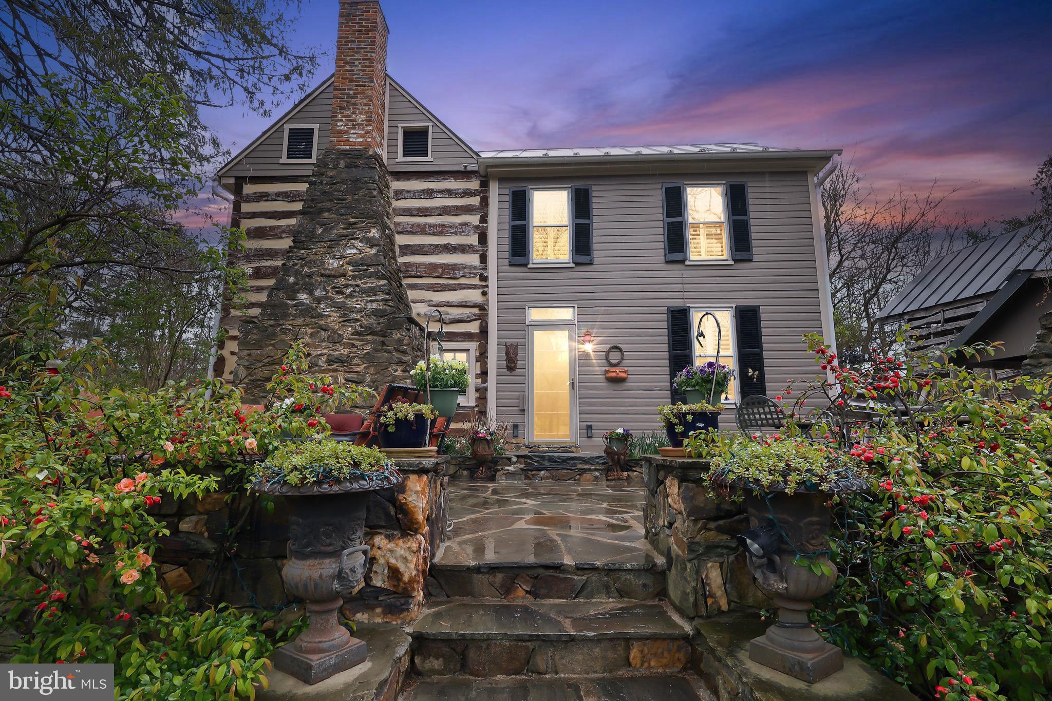 THE MANN HOUSE — A RARE OPPORTUNITY ON 12 ACRES
The Mann House is a 1740 log and stone estate on 12.08 acres in western Loudoun County, with frontage on Catoctin Creek. Built by John Mann on land originally purchased from Thomas Fairfax — cousin of Lord Fairfax — it's one of Virginia's oldest privately held homes, owned by just five families in nearly 300 years.
A Property With Options

Live in it, work it, or build a business around it. Zoned AR1, the property supports agricultural, equestrian, and low-density commercial uses. The land is suited to a hobby farm (goats, llamas, bees), boutique vineyard, farm winery, wellness retreat, bed and breakfast, short-term rental, or boutique wedding venue (subject to Loudoun County approval). Located just minutes from Loudoun's wine trail and Hillsboro's scenic corridor, with rolling pastures, wooded trails, and creek frontage. Historic designation may also qualify the property for state and federal tax credits on approved restoration or preservation work.
The Home

Three bedrooms, 2.5 bathrooms, 2,071 square feet. The original character is intact: hand-hewn log walls, wide-plank pine floors, two massive fieldstone fireplaces, and authentic wood paneling throughout. The kitchen has been updated with Argentine and Brazilian marble countertops, custom cabinetry, stainless steel appliances, and a striking exposed beam overhead — built for gathering. A stone-lined root cellar offers wine storage or a unique historic feature, and the original spring house, summer kitchen, and historic outbuildings remain on the property.
Built to Support a Bigger Vision
The infrastructure has been intentionally sized and updated to support both family living and business use:

Well: 963-foot deep private well connected to an underground river, rated for up to six (6) bedrooms. Big Blue whole-house filtration, flushing filtration system, and new pressure tank (February 2025).
Septic: Designed for a six (6) bedroom residence — providing ample capacity for expansion or commercial use. Holding tank and main tank upgraded with new pump, power, and alarm in Fall 2023.
Electrical: Two 200-amp panels (42-pole main + 24-pole secondary dedicated to kitchen and HVAC), plus Dominion Energy WiFi-monitored smart meter (2023).
HVAC: Two split-system 5-ton heat pumps (one per level), main level replaced 2020, upper level replaced 2023. Ductwork professionally cleaned with UV purification system (2024).
Roof: Standing seam metal on both the main residence and rustic log cabin — a true "install once" investment-grade roofing system.

Recent Updates

New LG stacking washer and dryer (September 2025)
New Bosch dishwasher (December 2025)
New pressure tank (February 2025)
Full plumbing, electrical, and HVAC inspections completed by Appleton Campbell (October–December 2024)
Ductwork UV purification system installed (December 2024)
Bath faucets and shower heads replaced (2023)

The Bottom Line
The Mann House offers the privacy and character of early colonial Virginia with the comfort and reliability buyers expect today — and well, septic, and electrical capacity built for far more than a 3-bedroom home. It's a legacy estate ready for family living, business vision, or both.
Offered at $999,000