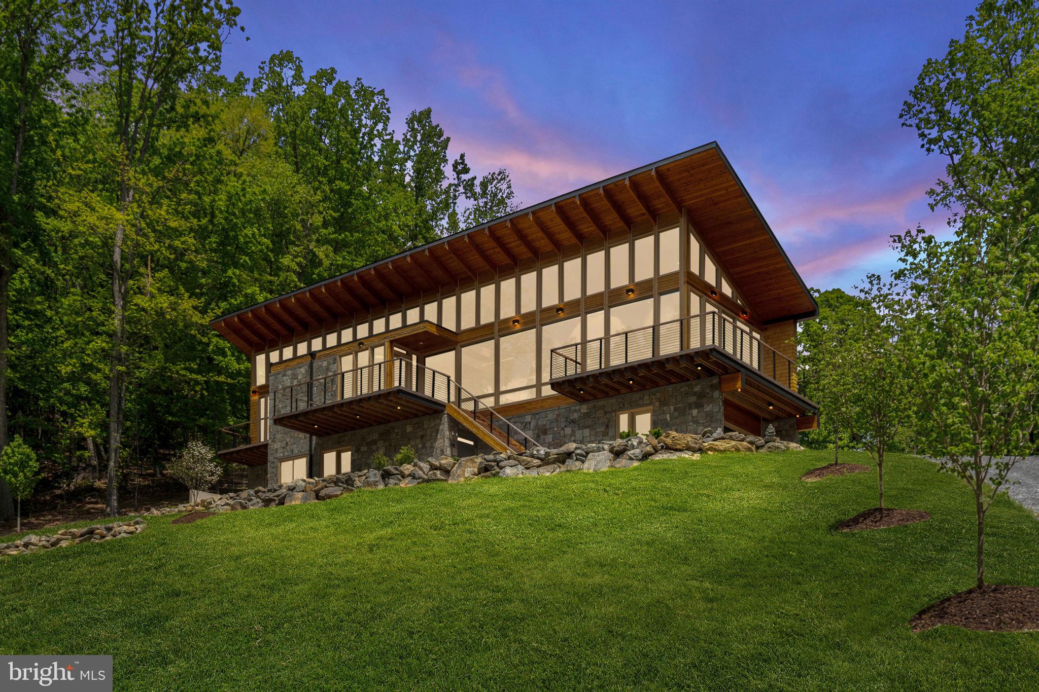 Some properties are just a place apart.  One of those special places is the Red Oak Mountain Retreat.  This 55 acre parcel features gently rising mountain land, a dramatic modernist house well positioned on the landscape, two bold running streams, and trails meandering through the woodlands.   Enhanced by thoughtful landscaping that blends nicely into the forest beyond, Red Oak Mountain Retreat is a true escape from the rest of the world.

RESIDENCE
Sited on a bluff about two thirds of the way up Red Oak Mountain, the residence was created in 2023 by a noted architect as a retreat for his own family.  The house is a sleek modern space designed to showcase the woodland landscape in all directions.  Soothing interiors in neutral colors allow the dramatic wood grain of the hand-selected douglas fir trim to take pride of place.   Modernist architecture with zen like placement of elements make this a calming retreat from the world.  Large windows and high ceilings in all rooms bring the views and allow light to flood each space.  The effect is a light and airy open living space in all rooms.

Views of Bessie Bell Mountain and the surrounding countryside are visible in the winter months, but the rest of the year the house is enveloped in a wall of greenery cascading up and down the mountain.   Rocky outcroppings at the house site have been incorporated into the landscape design and provide a focal point for the house entry way.   On the back side of the house the dramatic  floor to ceiling windows overlook a small valley with forested hillsides and mountains beyond.  The house is an extremely private oasis of calm.  Inside, carefully selected luxury finishes and energy efficient appliances and heating and cooling (including raidant heat in all floors) provide a sustainable living experience at the highest quality.

GROUNDS
The magic of Red Mountain Retreat is the utter privacy of the place.   While the architecture blends seamlessly with the landscape, the mountainside is its own captivating source of pleasure.   Old logging trails radiating from the house site allow for comfortable access to the mountain above and below.   A trail near the property entrance follows along a streambed through the woodlands.  There’s a lot to explore and absorb.

OTHER
Telecom:  Broadband internet is provided by Piedmont Broadband. (Starlink is also available in this location).   Cell phone coverage from T-Mobile and AT&T.

Location:  Red Oak Mountain Retreat is located in Castlteton, approximately 5 miles from the town of Washington, and 8 miles to village of Sperryville.   Approximately 73 miles from Washington, DC.  Travel time to downtown DC is 1 Hour 30 minutes (in low traffic situations).  Approximately 1 hour 20 minutes to Dulles International Airport.  1 hour to Charlottesville.  15 minutes to Culpeper, 25 minutes to Warrenton, and 25 minutes to Front Royal.

Amenities:  The charming small village of Sperryville which is home to Pen Druid Brew Pub, Headmasters Pub, Hopkins Ale Works, Francis Bar, Rappahannock Pizza Kitchen, the Corner Store, a gym, art galleries and shops, and the highly acclaimed The Three Blacksmiths restaurant.  “Little” Washington, the county seat of Rappahannock County is the home of The Inn at Little Washington, Foster-Harris House, Ballards, and galleries and theater. Rappahannock County is a close-knit rural community with excellent theater, concerts, art galleries, wineries, restaurants, and the Shenandoah National Park.