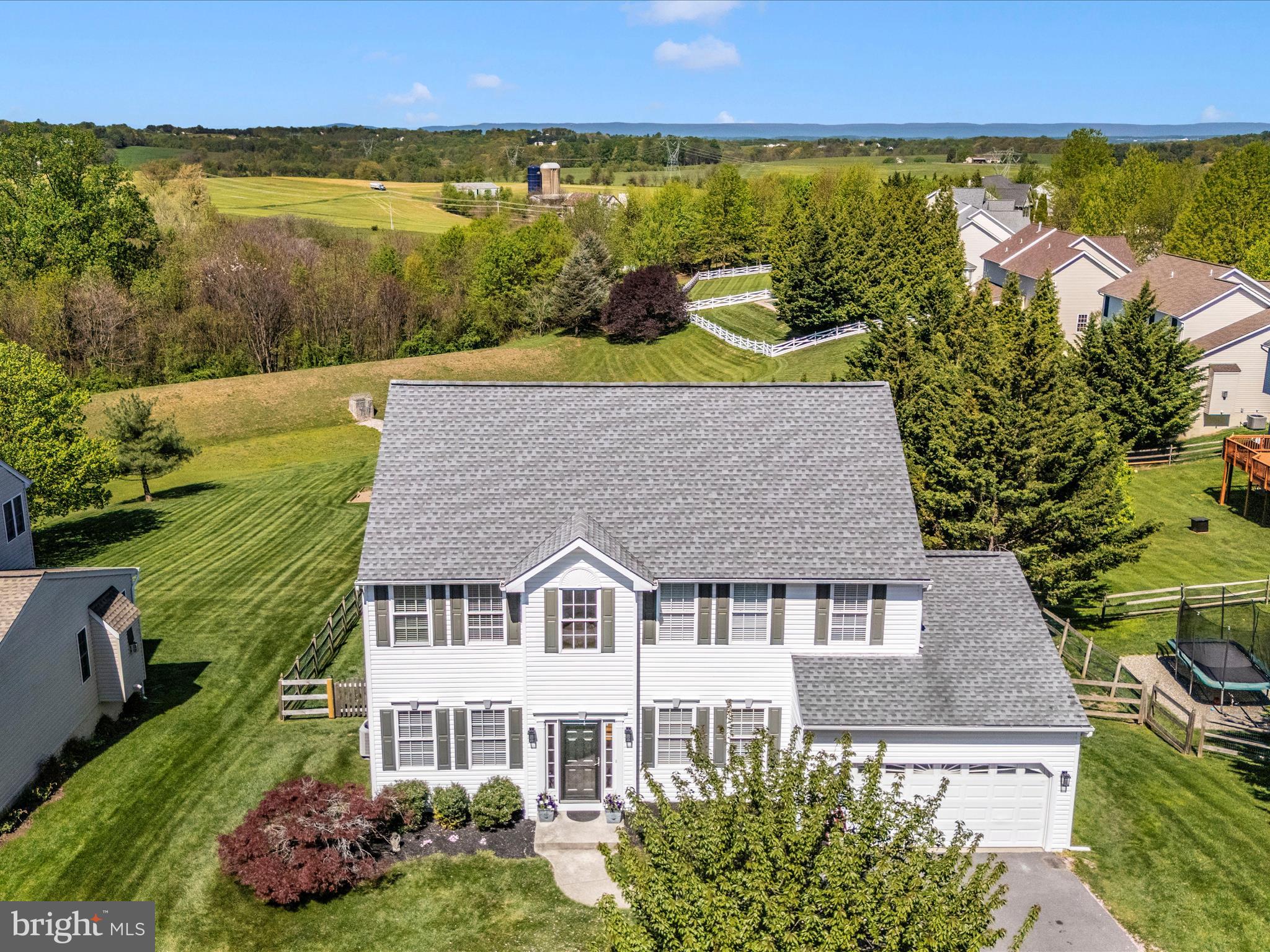 Welcome to this exceptional home, perfectly positioned on a private lot backing to open space with picturesque pastoral and mountain views—ideal for enjoying breathtaking sunsets. Located within walking distance of top-rated elementary and middle schools, charming downtown Mount Airy, local shops, restaurants, and community events, this home combines tranquility with unmatched convenience.
Nestled on a beautiful 0.51-acre lot, the fenced backyard is perfect for relaxing, entertaining, gardening, pets, or play. Meticulously maintained by the original owners, the home is in move-in-ready condition.
Inside, you'll appreciate fresh paint throughout most of the home, along with updated lighting and new carpeting. A bright and airy home office just off the foyer provides the perfect space for remote work. The adjacent formal living and dining rooms are ideal for hosting holidays and special gatherings.
At the heart of the home, the open-concept kitchen and family room create a warm and inviting atmosphere. The family room features a newer gas fireplace and access to the rear deck, while the kitchen boasts white cabinetry, granite countertops, a large island with seating, a breakfast area, and brand-new appliances. A convenient laundry room and powder room complete the main level.
Upstairs, the spacious primary suite offers a large walk-in closet and a beautifully renovated en-suite bath featuring a soaking tub, tiled shower, and dual-sink vanity. Three additional generously sized bedrooms and a fully renovated hall bath provide ample space for family or guests.
The expansive finished lower level includes a versatile recreation area perfect for media, gaming, fitness, or hobbies. A bonus room with a connecting full bath makes an ideal guest suite, office, or gym. Walk out to the paver patio and take in the serene panoramic views, or unwind on the elevated rear deck—perfect for grilling, outdoor dining, and watching the sunset over the distant mountains.
With endless possibilities for outdoor enjoyment and easy access to I-70, downtown Mount Airy, shopping, and dining, this home offers the ideal blend of privacy, beauty, and convenience.