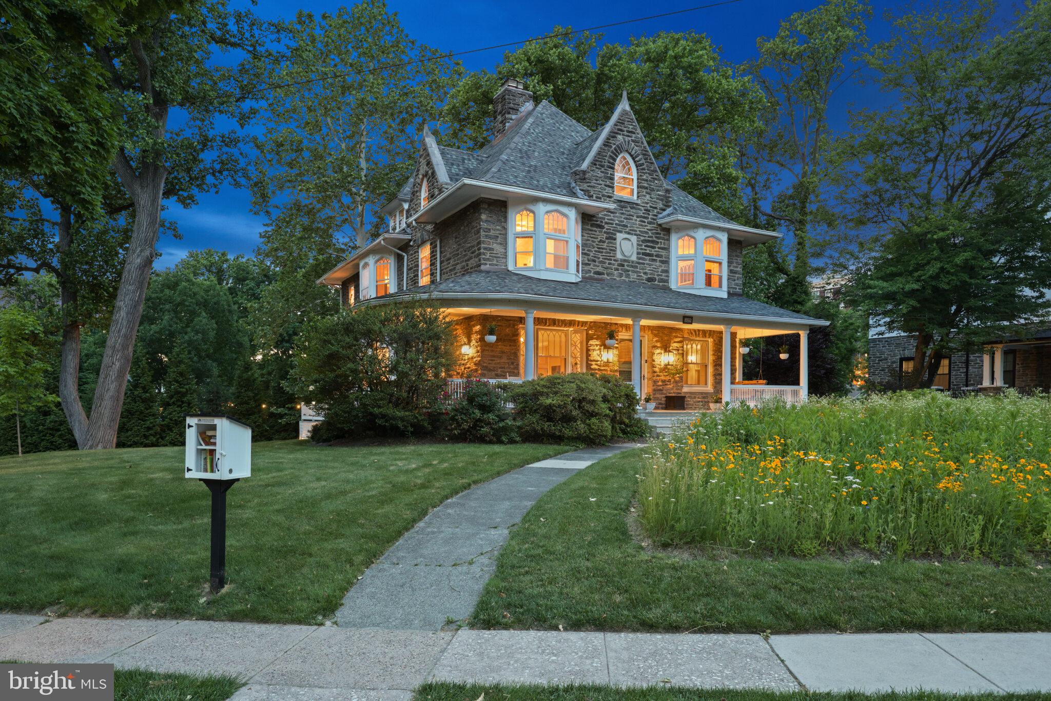 Welcome to one of West Mount Airy’s most treasured homes — a rare Victorian Gothic Revival estate in the heart of the beloved Pelham Historic District. Designed in 1895 by renowned Philadelphia architects Hazlehurst and Huckel, this remarkable residence feels like something from another time, when craftsmanship mattered and homes were built to last for generations.

Set on a picturesque tree-lined corner of Pelham Road, the home immediately captivates. A self-sustaining, native wildflower meadow blooms with color through spring and summer, leading to the wraparound porch where friends gather, conversations linger, and warm evenings seem to last forever. Pelham Road is known for its beauty, welcoming spirit, and deep pride of homeownership — the kind of street people dream of living on.

Built of iconic Wissahickon schist, this stone home beautifully blends historic character with modern luxury. Sunlight pours through leaded glass windows, illuminating soaring ceilings, custom crown molding, and gracious entertaining spaces designed for both grand gatherings and everyday living.

Lovingly restored and thoughtfully updated by its current owners, every improvement honors the home’s historic character while bringing effortless modern comfort. Major improvements include a new roof, full 3-zone HVAC replacement, updated electrical systems, three restored gas fireplaces, EV charging station, and an extraordinary four-car heated garage. At the center of the home is a stunning chef’s kitchen with an oversized island, wine bar, and direct access to the expansive deck — perfect for summer barbecues under the trees. With six bedrooms, three tastefully renovated full baths, two half baths, and a charming third-floor library and billiard room, the home offers exceptional space without ever losing its warmth.

A five-minute walk to Carpenter Station on the Chestnut Hill West Line makes for easy access to all that Center City’s arts and culture has to offer.

Timeless, turnkey, and deeply loved, this is more than a home — it is a legacy property waiting for its next steward.