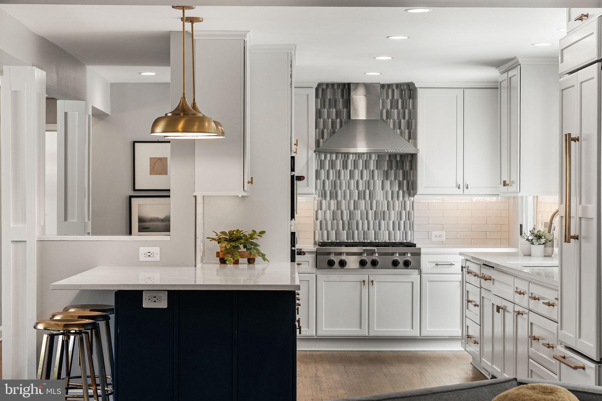 Welcome to 5400 Williamsburg, a beautifully updated home set on a 0.23-acre corner lot in a prime North Arlington location with convenient access to nearby shops, restaurants, parks, and major commuter routes. Ideally positioned within the Discovery, Williamsburg, and Yorktown pyramid, this home provides easy access to everyday amenities and a connected lifestyle in one of Arlington’s most desirable neighborhoods.

The main level features recently refinished hardwood floors and a spacious living room filled with natural light. The kitchen and dining area were thoughtfully reconfigured and remodeled in 2019, including layout changes, new cabinetry, updated windows, and upgraded appliances, representing a significant investment of approximately $150,000. The result is a seamless, open flow ideal for both daily living and entertaining, with abundant cabinet and counter space, breakfast bar seating, a gas cooktop, and a wall oven. The dining area is anchored by a fireplace, creating a warm and inviting focal point for gatherings. Three well-proportioned bedrooms and a full bathroom are also located on this level.

The private primary suite is set apart on its own upper level, creating a true retreat within the home. This space features two large walk-in closets, access to a private balcony, and a spacious en suite bathroom with extensive vanity counter space, a soaking tub, and an oversized shower.

The fully finished lower level adds valuable additional living space, including a large family room, a full bathroom, and two flexible bonus rooms ideal for a home office, guest space, gym, or additional living areas. Additional updates include a replaced hot water heater in 2022, contributing to overall peace of mind.

Outdoor living is a standout feature, with a fully fenced yard and an expansive bluestone patio completed in 2021. Designed for entertaining, this nearly $60,000 outdoor space includes a built-in fire pit and grilling station constructed with heat-retaining refractory bricks, along with imported grill hardware from Argentina, creating a unique and functional setting for gatherings or quiet evenings at home. A heated two-car garage adds convenience, functionality, and additional storage.

Enjoy easy access to the Lee Harrison Shopping Center, including Harris Teeter and a handful of restaurants, along with outdoor spaces such as Chestnut Hills Park. Commuters will appreciate quick access to Route 29, I-66, and the George Washington Parkway, making travel into DC and throughout Northern Virginia seamless.

With major updates throughout, a functional multi-level layout, and an unbeatable location that blends neighborhood charm with everyday convenience, 5400 Williamsburg offers a well-rounded lifestyle in the heart of North Arlington.