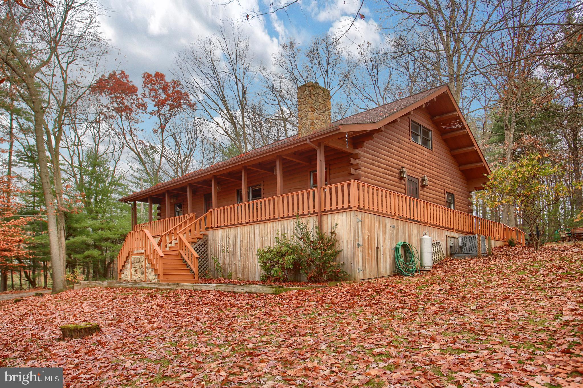 Pride of ownership is evident in this beautiful 3 bedroom, 2 bath log home sitting on 4.97 picturesque acres. First floor features an open living area with 2 bedrooms, full bath, beautiful kitchen with Corian counter tops and newer stainless steel appliances, two dining areas and a spacious family room with a stone wood fire place. Retreat to the 2nd floor which features open views of the downstairs , a large "loft bedroom" with a full bath and a catwalk to 2nd loft area. The finished basement affords many possibilities and includes a separate family room with a built in bar and bedroom with outside access. Step outside to the beautiful wrap around porch and deck for truly amazing views. For added conveinence, this home also offers a large detached oversized two car garage with a loft and fireplace. This home has had many recent updates which include, but are not limited to: New Roof (2020), New A/C Unit (2020) Freshly painted detached garage (2020), Freshly painted deck and wrap around porch (2020), Driveway Seal coated (2020) Tiled bathroom floors (2020) and freshly stained hardwood floors in lofts (2021). This home is truly one of a kind!