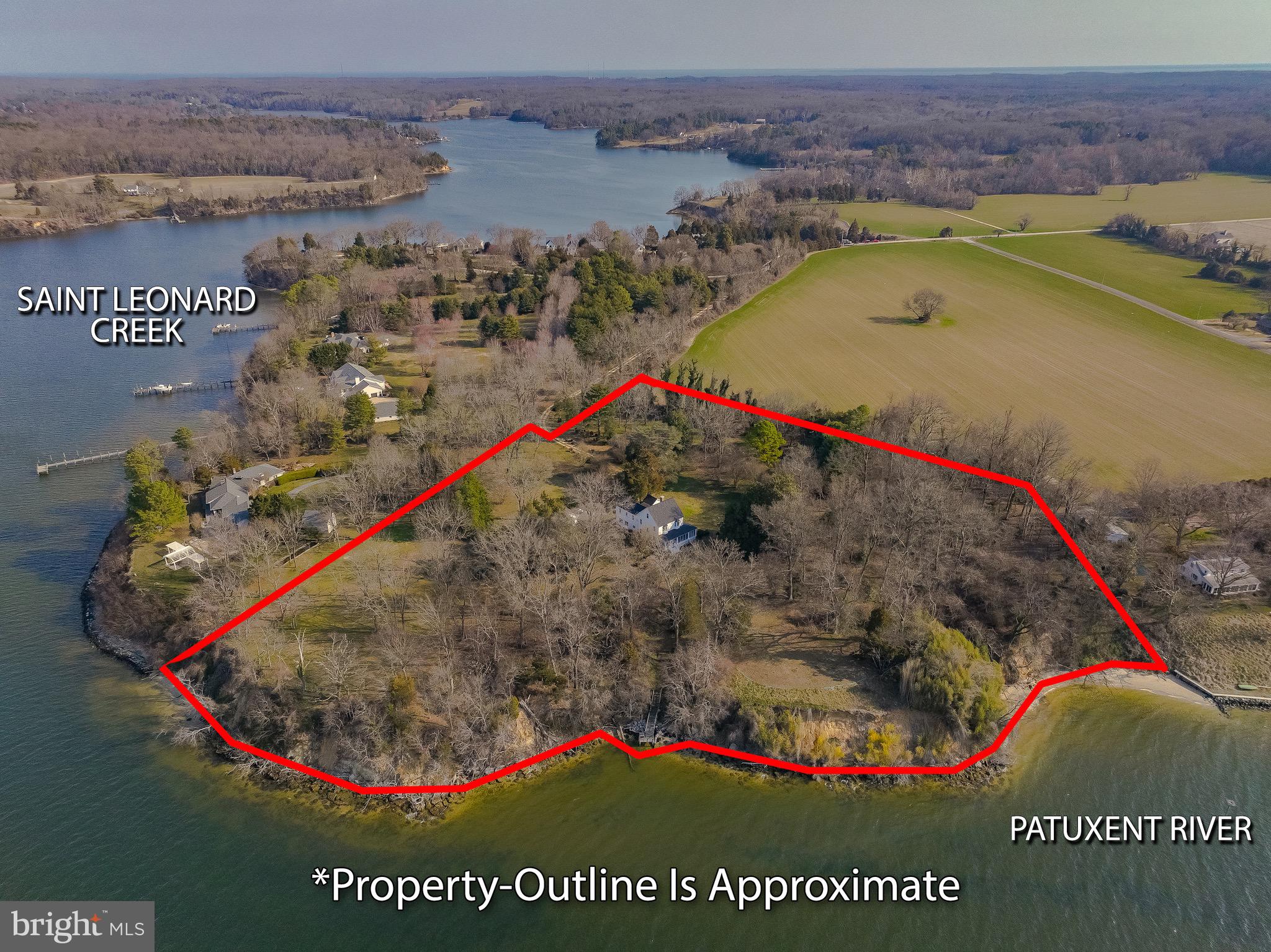 New brokerage, New Price!!!

Situated where the Patuxent River meets St. Leonard Creek, this serene 8.21-acre waterfront retreat offers exceptional privacy, sweeping views, and a timeless home rich in character and history. Built in 1907 and lovingly maintained by the same family since 1935, this four-bedroom, three-bath residence blends timeless character with comfortable living.
A welcoming grand foyer opens to an expansive Living room and an elegant Dining room featuring built-in cabinetry and gleaming hardwood floors that extend throughout the home. The bright, open kitchen is equipped with newer stainless-steel appliances and flows seamlessly into a casual Dining and Family gathering area. Custom built-ins provide dedicated desk and computer space, while a nearby laundry area and secondary staircase add everyday convenience. A spacious half bath completes the main level. Generous room sizes and graceful flow make the home ideal for entertaining—having hosted weddings, receptions, holiday celebrations, and countless gatherings where guests enjoyed the peaceful setting and remarkable water views.
Upstairs, a striking staircase leads to four bedrooms and two full baths. The Primary Bedroom  offers beautiful river frontage views.  A large open area with commanding views of the Patuxent River offers the perfect space for relaxation,   or the opportunity to expand the existing Primary Bedroom, creating a luxurious suite. A wide staircase provides easy access to the attic for additional storage. Three additional bedrooms and a second staircase complete the upper level.
The riverfront wrap around screened porch creates an inviting setting for dining, entertaining, or simply unwinding while enjoying cool breezes and breathtaking sunsets. Panoramic views from the river bank stretch from the Governor Thomas Johnson Bridge to Broomes Island, offering an ever-changing waterfront backdrop.
Approximately 380 feet of shoreline extend along the Patuxent River into the mouth of St. Leonard Creek, known for its excellent sailboat anchorage. History enthusiasts will appreciate that the largest naval battle fought in Maryland during the War of 1812 occurred just off this shoreline. The property’s waterfront also reveals abundant marine fossils along the water’s edge.
This private eight-plus-acre retreat adjoins the neighbors over 20 acres of protected farmland, enhancing the sense of seclusion and natural beauty. The original owners were avid gardeners, and many of their plantings remain part of the landscape today—including magnificent Southern magnolias planted around 1936, along with black walnut, holly, weeping cherry, and hemlock trees—creating a truly picturesque and enduring setting. Point of interest---Home to the second largest Atlas Cedar tree in Maryland!!
Additional features include a detached three-car garage, a gardening shed, and the freedom of no HOA or restrictive covenants. Modern updates enhance efficiency and peace of mind, including a four-zone geothermal heating and cooling system, a new roof installed in 2023 with CertainTeed architectural shingles (limited lifetime transferable warranty), fresh paint and recently refinished hardwood floors by Wells Flooring.

Properties offering this combination of premier waterfront location, significant acreage, rich history, and meticulous  care are exceedingly rare. This is a truly special opportunity for a discerning buyer seeking something extraordinary.
Ideal for full time living while enjoying all of the benefits of being close to Solomons Island with its many choices of restaurants, first class marinas, Calvert Marine Museum and Ann Marie Sculpture Gardens.  Weekends offer many choices of concerts and festivals.  If you are looking for a weekend getaway with lots of privacy, only 90 minutes from the Capitol enhanced by no need to cross the dreaded Bay Bridge!
Property lines as seen in photos are approximate.