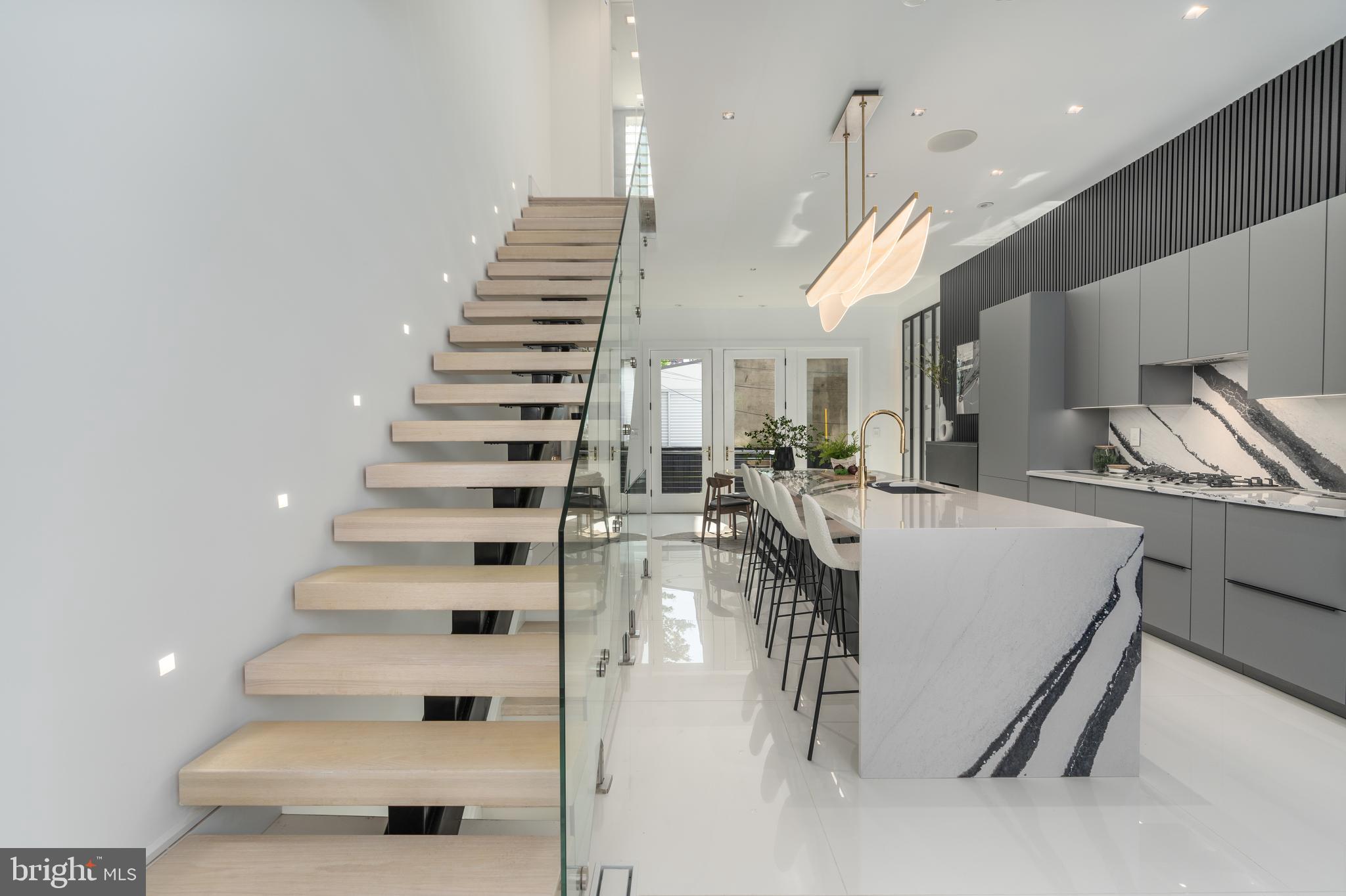 Introducing an exquisitely transformed row home, a veritable masterpiece that redefines opulent living. Nestled in an awe-inspiring location, mere steps away from the renowned Logan Circle, this captivating four-level townhouse boasts an impressive configuration of 4 bedrooms and 3 full
bathrooms, sprawling across an expansive 2900 square feet. Prepare to be spellbound by the
unparalleled contemporary design elements that adorn every inch of this abode. Every facet of this residence has been painstakingly fashioned with meticulous attention to detail; from the bespoke floating staircase adorned with glass railing to the soaring 11-foot ceilings and majestic 8-foot-tall solid wood doors, no expense has been spared. The Poggenpohl kitchen cabinets, enhanced by sleek black fluted walls, and a collection of professional-grade chef appliances, including an indulgent Miele coffee station, converge to create a true epicurean haven. Brilliantly bright, the main floor showcases European tiles, a stylish dining room, a living room boasting a fireplace, and a deck that overlooks a serene private backyard.
On all other levels, the hardwood floors radiate an air of timeless elegance, enhancing the overall
splendor. Boasting 3 full bathrooms and 4 bedrooms featuring Italian Poliform organized cabinets,
the living spaces are also suffused with an abundance of natural light. The meticulously landscaped
front and back yards, adorned with accent lighting, contribute to an inviting ambiance that is simply
unmatched.
Through to the open-concept kitchen, resplendent with custom Poggenpohl cabinetry, state-of-the-art Miele cooktop, stove, and coffee station appliances - a dream come true for those who relish the art of entertaining. Handpicked island and countertop surfaces, complemented by fluted wall panels,
designer lighting, and top-of-the-line fixtures, combine to create an unforgettable culinary
experience. The owner's suite commands the entirety of the third/top floor, serving as a luxurious sanctuary that encapsulates pure indulgence. Boasting a skylight, a separate laundry area, a generously proportioned bedroom with a cozy sitting area, and an Italian Poliform organized closet, this suite exudes grandeur. Immaculate design continues in the master bathroom showcasing floor-to-ceiling
tiles, bespoke cabinetry, double sinks, a temperature-controlled toilet/bidet, a Kohler digitally controlled spa experience shower complete with a cascading waterfall, and a freestanding oversized tub.
The lower level of the property provides additional space for family gatherings, featuring a charming rec-room, a fireplace, a full bath, a bedroom, a washer/dryer, a wine cooler, wine storage, and a
separate rear entrance, with a delightful rear patio serving as an idyllic oasis for relaxation or outdoor entertainment.
Premium comfort and premier living are on offer here with amenities including cutting-edge Legrand
Adorne touch lighting switches, an unparalleled sound system permeating every corner, and built-in
security features. Ideally positioned just minutes away from the city's most exceptional restaurants, shopping destinations, grocery stores, public transportation hubs, and a host of other
amenities, this townhouse offers an exquisite fusion of luxury, convenience, and style.
Seize the opportunity to make this extraordinary property your new home and embark on a life of
unrivaled grandeur. It is also offered for rent at $12,000 monthly. Monthly parking space available across the street. Days on the market is not a true reflection of how long the listing has been active on the market.