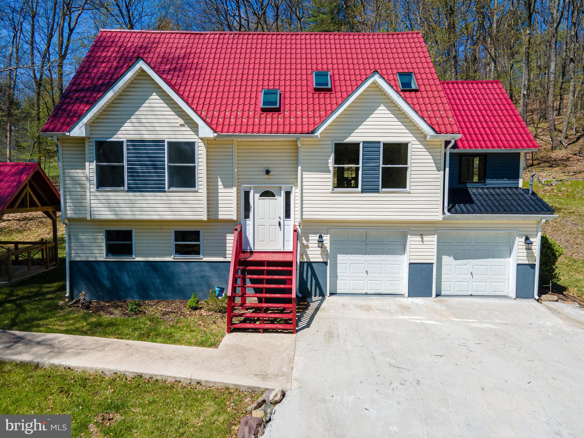 Nestled in the heart of East Stroudsburg, this stunning 4-bedroom, 3-bath lakefront home offers the perfect blend of comfort, style, and natural beauty. Solid bamboo flooring flows throughout the home, while the impressive 2-story open-concept living and dining areas showcase soaring vaulted ceilings, skylights, and rustic wood beams that fill the space with warmth and natural light. The gourmet kitchen is designed to impress with tile floors, Quartz countertops, tiled backsplash, American cherry cabinets, recessed lighting, stainless steel appliances, and a double sink. A partially separate family room provides a cozy retreat featuring an elegant chandelier and a striking stone fireplace with mantel. The main level also includes 2 generously sized bedrooms and an updated full bath with tile floors, vessel sink with tile backsplash, and tub/shower combo. Upstairs, a finished loft sitting area overlooks the living room, creating the perfect space for a home office, reading nook, or relaxation area. The luxurious master suite features dual walk-in closets, a private balcony, and a modern full bath complete with tile floors, granite-topped vanity with dual sinks, tiled corner walk-in shower, and tiled soaking tub. The fully finished lower level offers incredible flexibility and can serve as a rec room, guest suite, or additional bedroom, complete with its own full bath featuring tile floors and a tiled tub/shower combo. Step outside to your own private outdoor oasis where a manmade lake with fountain and fish creates a serene backdrop. Entertain beneath the metal-roofed gazebo while enjoying breathtaking panoramic mountain views surrounded by trees for the ultimate nature experience. A 2-car garage and concrete driveway provide ample off-street parking, completing this one-of-a-kind property. Conveniently located close to major highways I-80 and PA-611 for easy commute, Black Forest Campground, Glenoak Lake, shops, restaurants, parks and so much more!