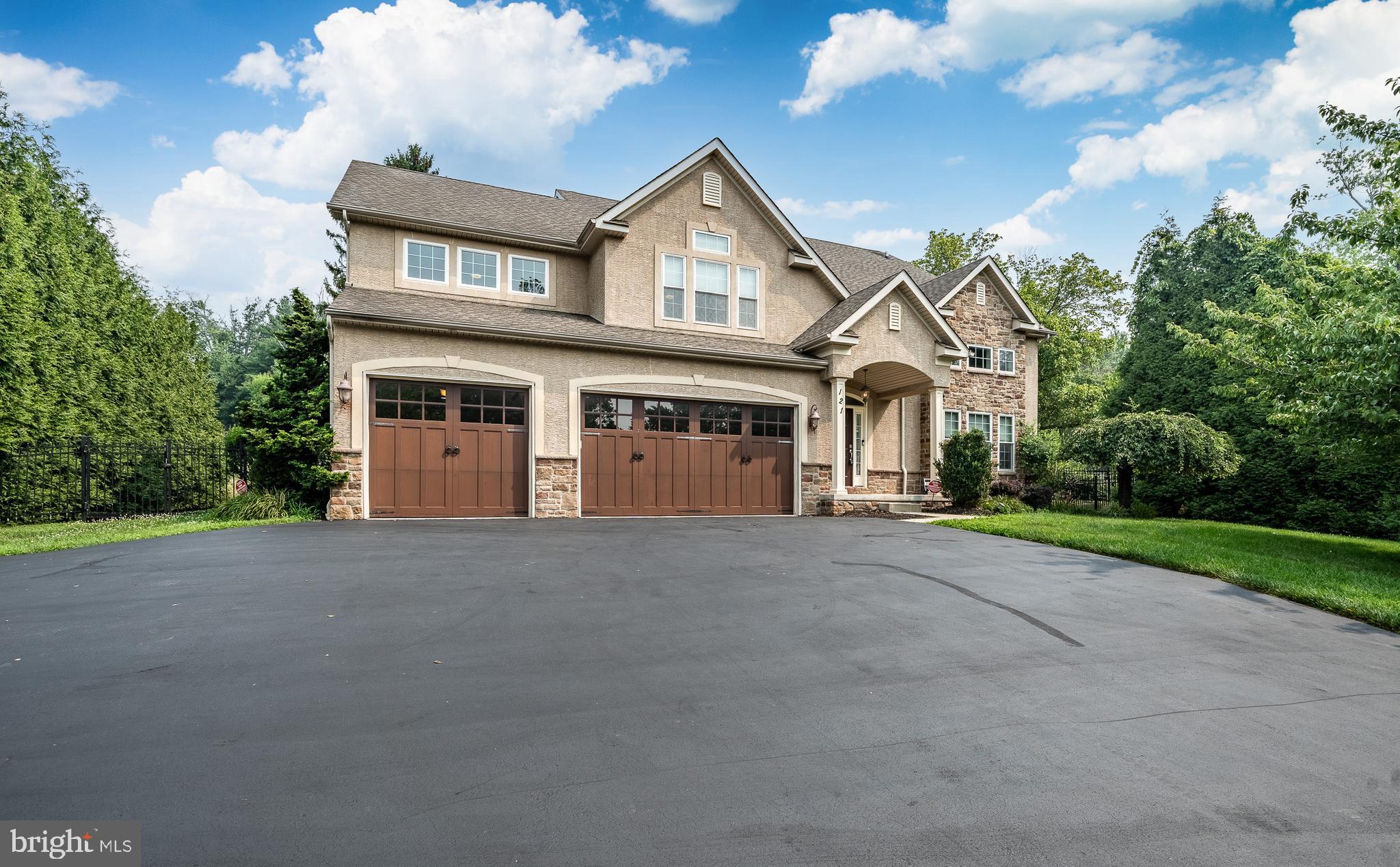Exceptional curb appeal sets the stage for this stunning home, where professionally designed landscaping, an oversized driveway and a spacious three-car garage create an unforgettable first impression. Step inside to discover over-the-top craftsmanship and thoughtful design, featuring six bedrooms, five full bathrooms, soaring 18-foot ceilings, rich hardwood flooring, extensive custom moldings, two gas fireplaces and an abundance of natural light throughout. Designed for both everyday living and effortless entertaining, the expansive family room flows seamlessly into a spectacular chef's kitchen. This impressive space features a large granite island with seating, 42-inch maple cabinetry, stainless steel appliances, a travertine tile backsplash, a gas cooktop with pasta pot filler, a generous walk-in pantry, and abundant recessed lighting. A private main-level office with an adjacent full bath offers exceptional flexibility and can easily serve as a guest suite or first-floor bedroom. The elegant staircase, accented with wrought-iron balusters, makes a striking architectural statement as it leads to the second level. The luxurious primary suite is a true retreat, showcasing a tray ceiling, continued hardwood flooring, recessed lighting, a charming built-in window seat with storage, and an expansive custom walk-in closet. The spa-inspired ensuite bath includes dual vanities, a soaking Jacuzzi tub, a beautifully tiled glass-enclosed shower and a private water closet. A spacious secondary bedroom enjoys the privacy of its own ensuite bath with tile flooring, a granite-topped vanity and a tub/shower combination. Two additional generously sized bedrooms share a thoughtfully designed Jack-and-Jill bathroom, providing both comfort and convenience. The finished lower level adds approximately 1,100 square feet of exceptional living space, complete with a sixth bedroom, a fifth full bathroom, abundant storage, and endless possibilities for recreation, guests, or multigenerational living. Outside, the meticulously maintained grounds are enhanced by extensive landscaping and hardscaping, including a fully fenced backyard, landscape lighting, stacked stone retaining walls, and a beautiful paver patio—creating the perfect setting for outdoor entertaining. Additional improvements include extensive basement waterproofing for added peace of mind. This remarkable home is also equipped with a whole-house generator, dual-zone HVAC, whole-home humidifier and dehumidifier, water filtration system with a dedicated filtered drinking water faucet, custom top-down/bottom-up blinds, Nest thermostat and many other premium upgrades. Situated on just over half an acre in the highly desirable Methacton School District, this exceptional property offers convenient access to major highways, Providence Town Center and an array of shopping and dining destinations. Luxury, functionality, and timeless style come together in a home that truly checks every box.