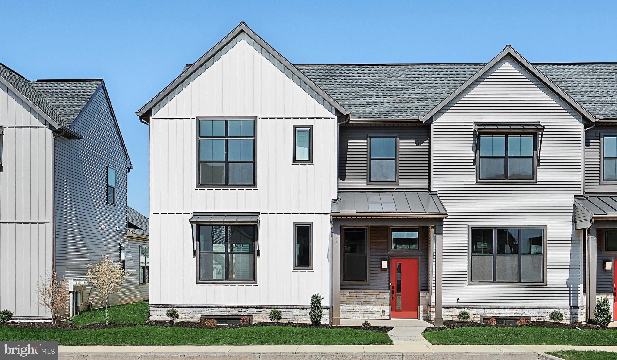 This 2-story, end-of-row townhome includes a first-floor owner’s suite, 2-car, rear load garage and a mudroom entry with built-in lockers and bench. Beautiful vinyl plank flooring adorns the main living areas on the first floor. The living room, accented by a stone fireplace, opens to the kitchen and dining area with sliding glass door access to a patio. The kitchen is well-appointed with stainless steel appliances, quartz countertops with a tile backsplash, and large center island. The owner’s suite, tucked quietly to the back of the home, features an expansive closet and a private bathroom with a tile shower and double bowl vanity. A laundry room is conveniently located across the hall from the suite. On the 2nd floor is a loft, two additional bedrooms, and a full bathroom. Images may include virtual furnishings for illustrative purposes only.