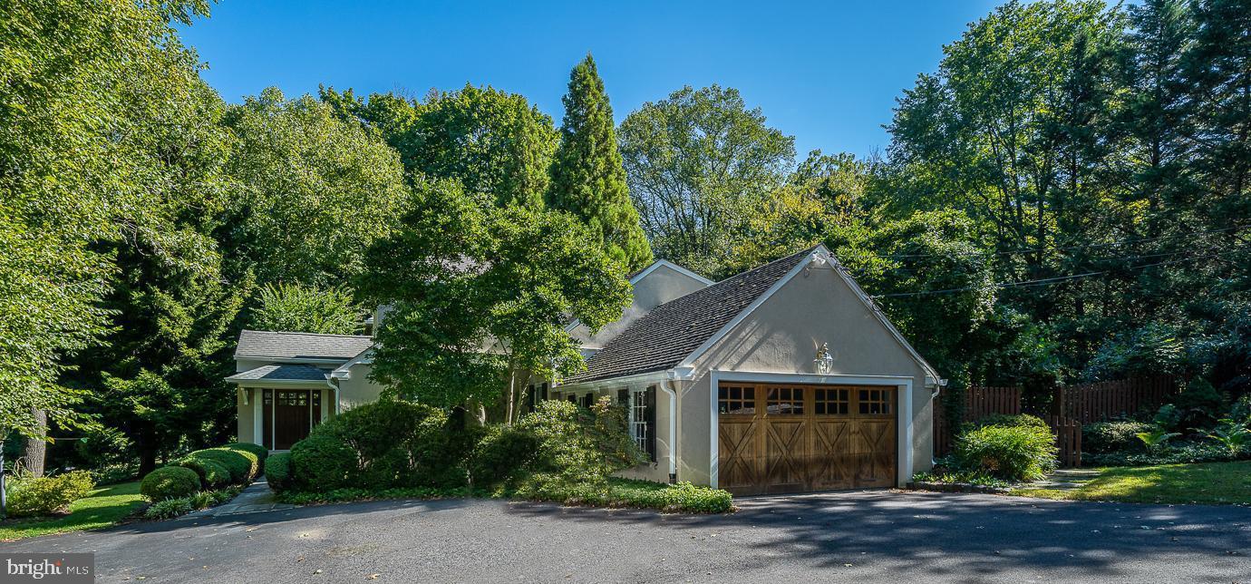 Enjoy the tranquility and convenience of this beautiful 5 bedroom, 4 full bath Penn Valley home with a separate 950 square foot Carriage House. Sitting on a private, park-like, interior 1.12-acre lot with a tree-lined perimeter, this 3,925-square-foot home is flooded with sunlight and offers serene views from every window. The center hall leads to the large formal living room with crown molding, a wood-burning fireplace, and beautiful hardwood floors that flow throughout the 1st floor.  French doors open to the cozy, centrally located family room overlooking the fenced-in backyard.  Off the family room is a separate office/bedroom with a full bathroom and access to the oversized shaded deck that overlooks the wonderful inground pool and is the perfect spot to enjoy the shade on a warm summer's day.  The formal dining room is perfect for hosting dinner parties both intimate and grand and sits just off the kitchen.  The spacious chef’s kitchen with ceramic backsplash, granite countertops, a large island with seating, a double wall oven, and a Sub-Zero refrigerator offers ample counter space and storage and is open to the sunlit breakfast room with vaulted ceilings, overlooking the lush grounds  From here is the mudroom with French doors to the back patio with pergola and access to the 2 car garage.  An additional bedroom and a full bath complete this level.  Head up to the 2nd floor where you will find the spacious primary bedroom suite featuring a dressing area that opens to the walk-in closet and full ensuite bath with frameless shower and soaking tub area. There are two additional bedrooms, one with a separate sitting room and a full hall bathroom on this level. The finished lower level offers the perfect space for a game or theatre room, and also includes a laundry room and a large wine cellar.  Step outside and enjoy the sounds of nature and stroll down to the sizeable Carriage House that offers tons of possibilities…guest house, nanny suite, separate in-laws space, or even a rental property.  This 950 sq ft 2- story carriage home features its own kitchen, a living room with a wood-burning fireplace, 2 bedrooms, and a full bathroom with laundry.  Located in the award-winning Lower Merion School district and close to everything, this home is the perfect balance of accessibility and harmony.