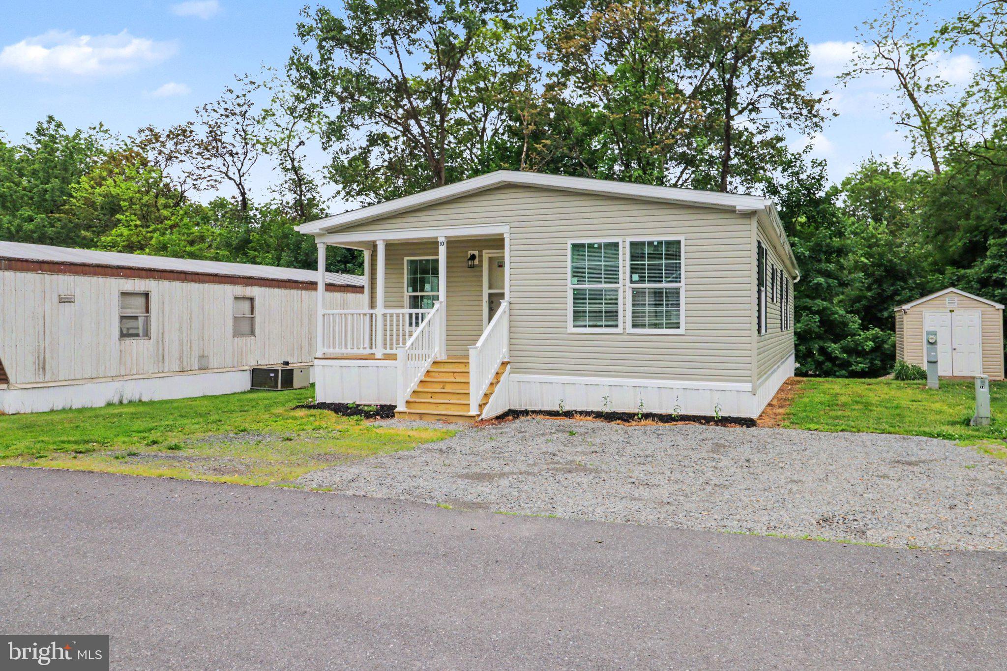 Be the first to call this newly constructed mobile home your own. From the covered front porch to the bright, open interior, this home offers the comfort of new construction with a practical, low-maintenance layout designed for everyday living.

Step inside to an inviting open floor plan filled with natural light, neutral finishes, crown molding, recessed lighting, and attractive flooring throughout the main living areas. The kitchen is a standout feature, offering warm wood cabinetry, a center island, stainless steel appliances, generous storage, and plenty of counter space for cooking, gathering, and daily routines.

The home also includes a dedicated laundry/mudroom area with exterior access, giving you a functional drop zone for everyday use. The primary bath offers a spacious retreat with a soaking tub, separate shower, large vanity, and modern fixtures, while the second full bath adds flexibility and convenience.

Outside, enjoy a covered front porch, off-street gravel parking, a manageable yard area, and a storage shed for added utility. With everything new and ready for its first owner, this home is a great opportunity for buyers looking for comfort, simplicity, and a fresh start in a community setting.